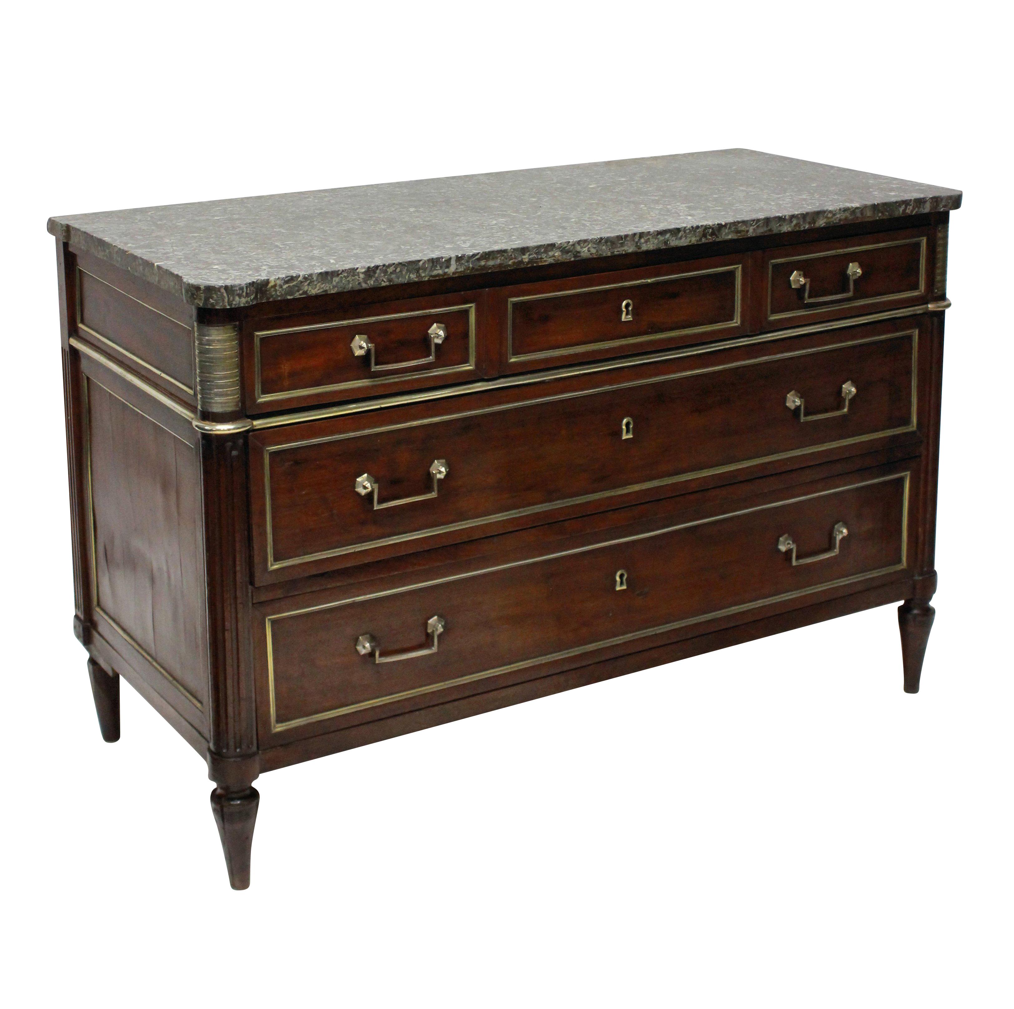 A French Directoire commode in mahogany with oak lined drawers and brass detailing to the drawers, fluted legs, handles and key holes. With its original variegated marble top with a hand written label verso.