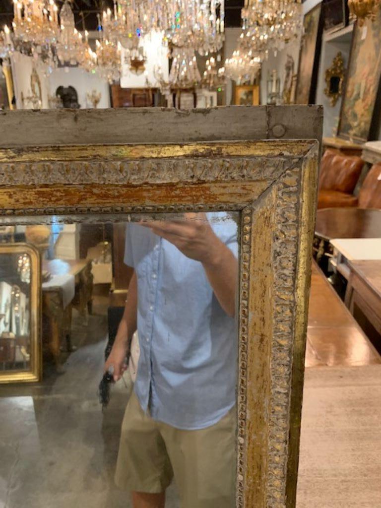 Beautiful 18th century Directoire giltwood mirror. The mirror has 2 panels of original mercury glass. The patina is lovely on this piece. It is painted white with gold gilt, giving a very glistening effect. So pretty!