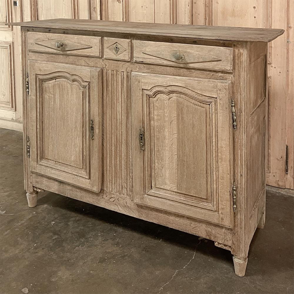 18th century Directoire Period Country French buffet in stripped oak is a splendid example of the tailored architecture made popular just before and after the turn of the 19th century. Hand-crafted from seasoned old-growth oak, it features a