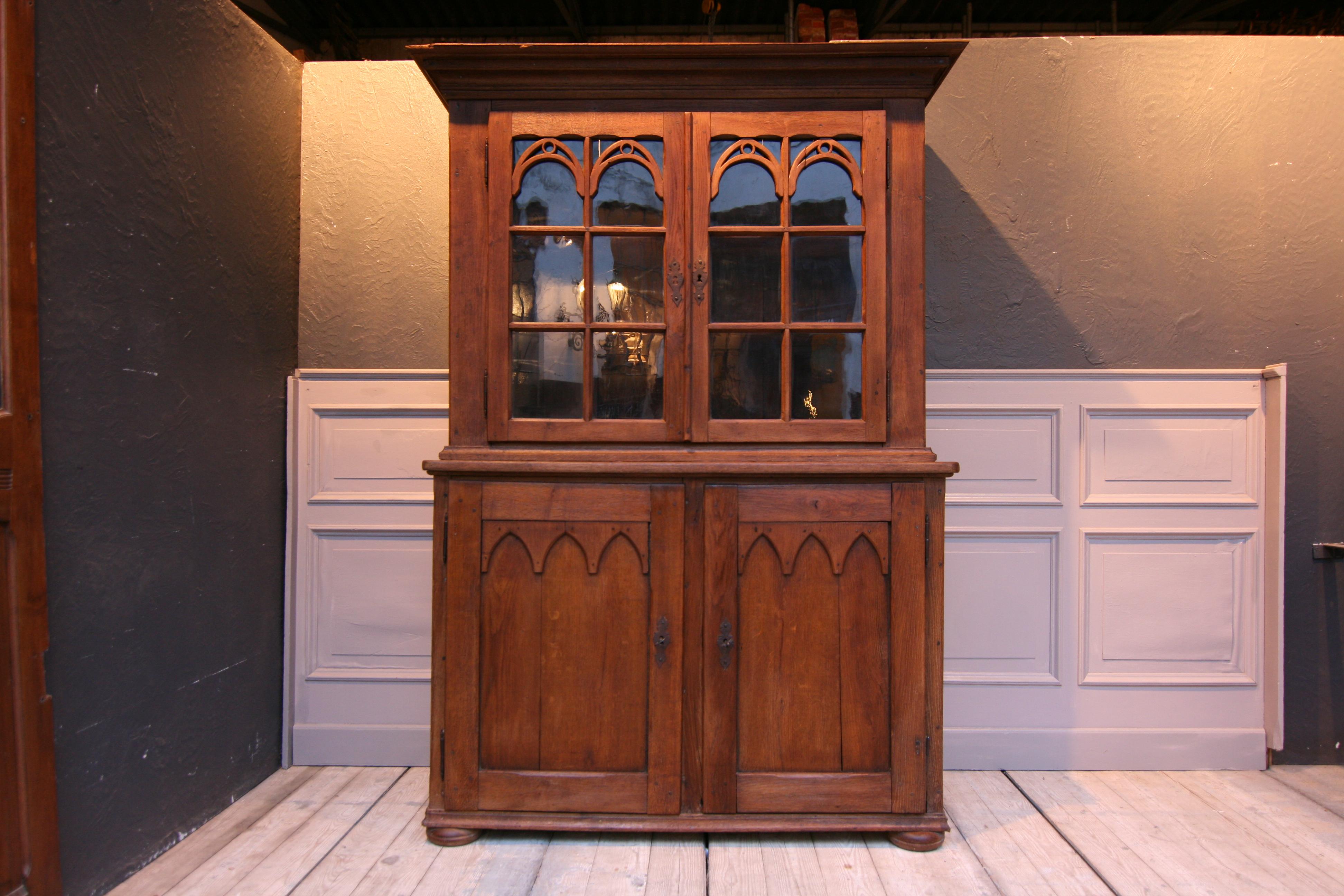 Beautiful Provincial display cabinet from the 18th century made of solid oak. 
Consisting of an upper part and a lower part.
The upper part features 2 showcase doors, hanging on external hinges, with trace work in which is the old glass. There are 3