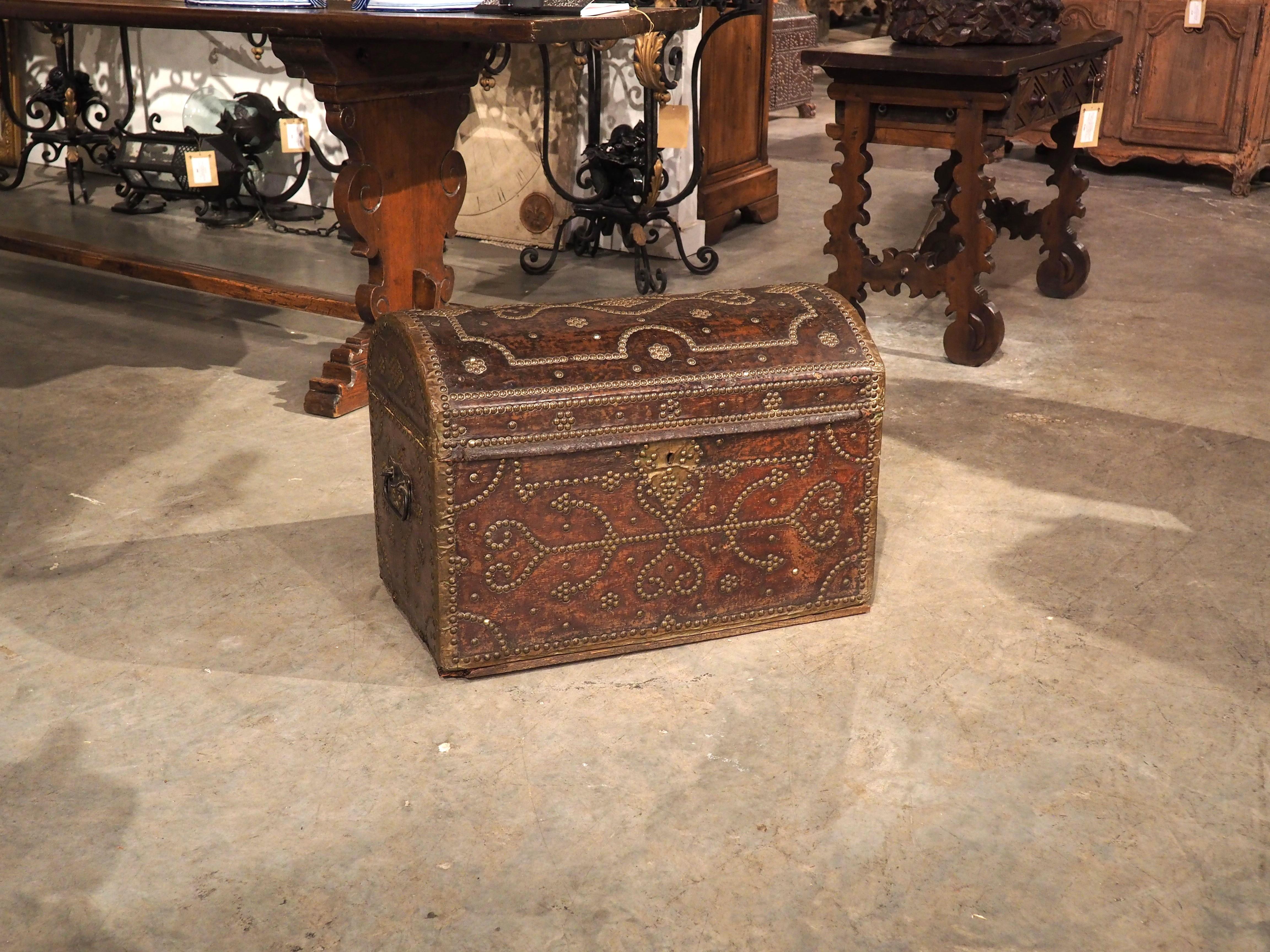 Beautifully designed and highly portable, this French domed top trunk was constructed by hand with a wooden body enveloped in chocolate-colored leather. The trunk, which dates to the 1700s, also features meticulously placed nailheads forming
