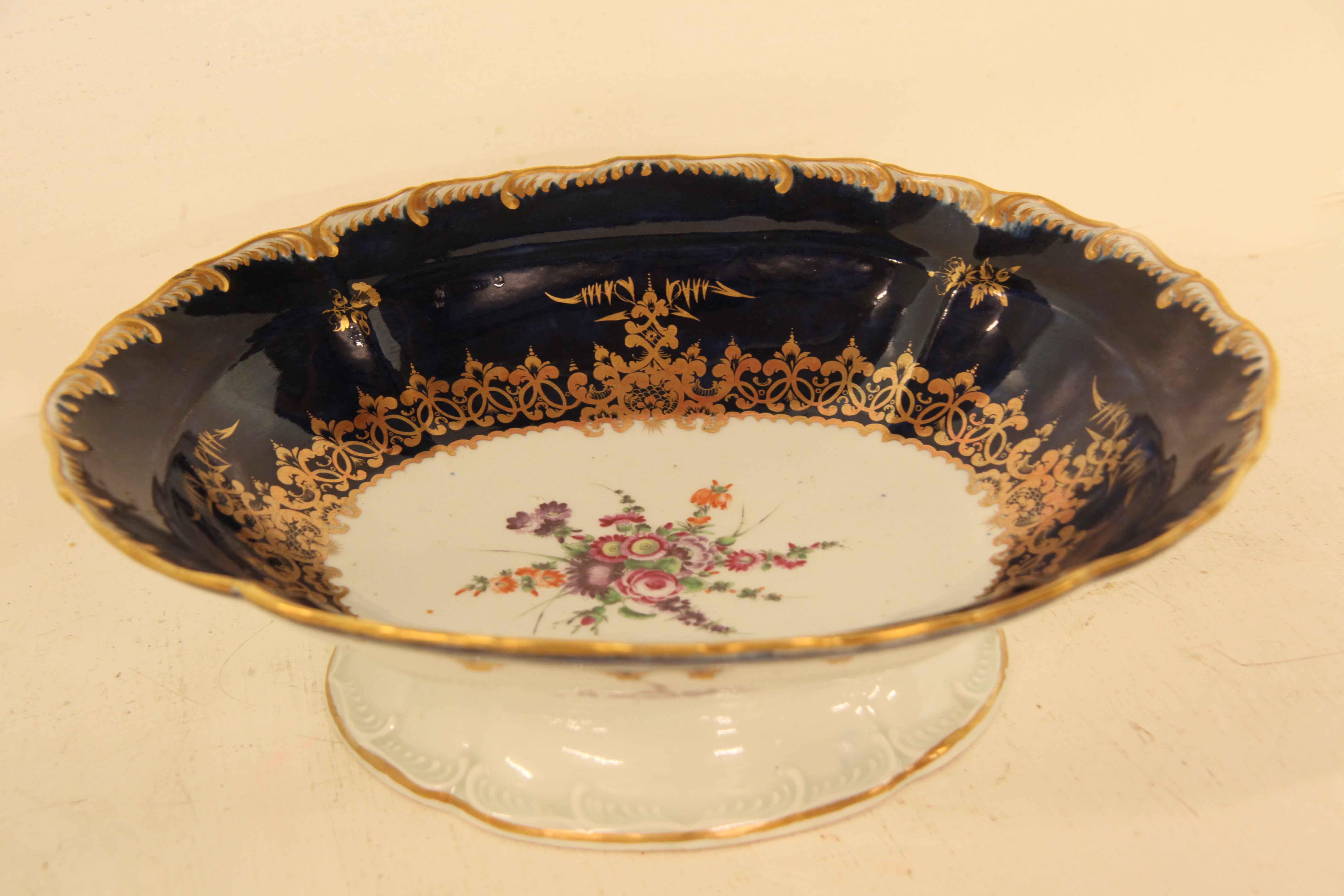 18th century Dr. Wall Worcester oval dish, the scalloped edge rim is beautifully gilt followed by a dark cobalt interior with gilding .  The open center features a bouquet of flowers in various colors and sizes.  The exterior has a cobalt and gilt