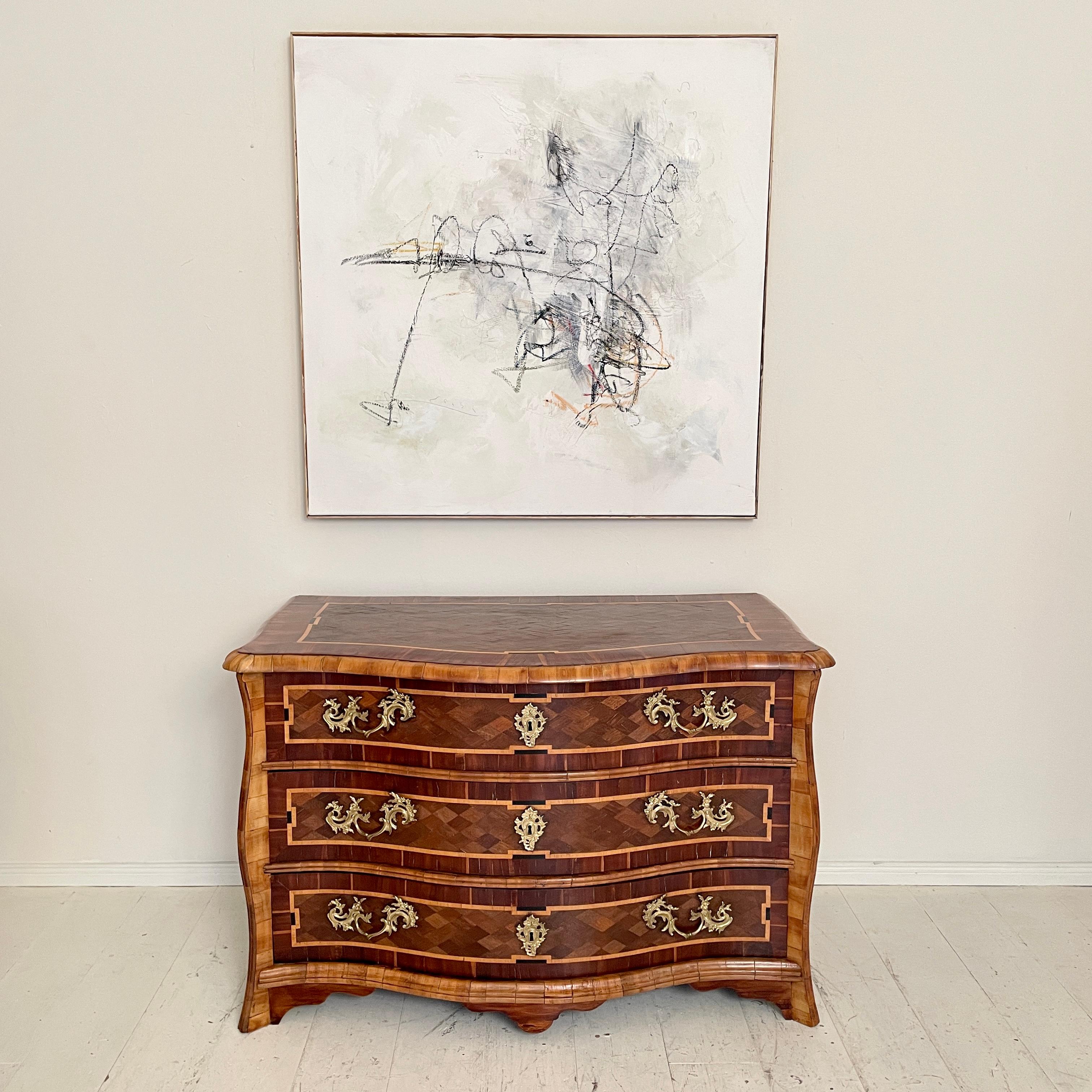 This beautiful 18th Century Dresdner Baroque Commode was made around 1760.
The pine corpus is veneered in Veilchen wood, amaranth and walnut. The bronze fittings are replaced but they are from a fantastic quality and are how the original would have