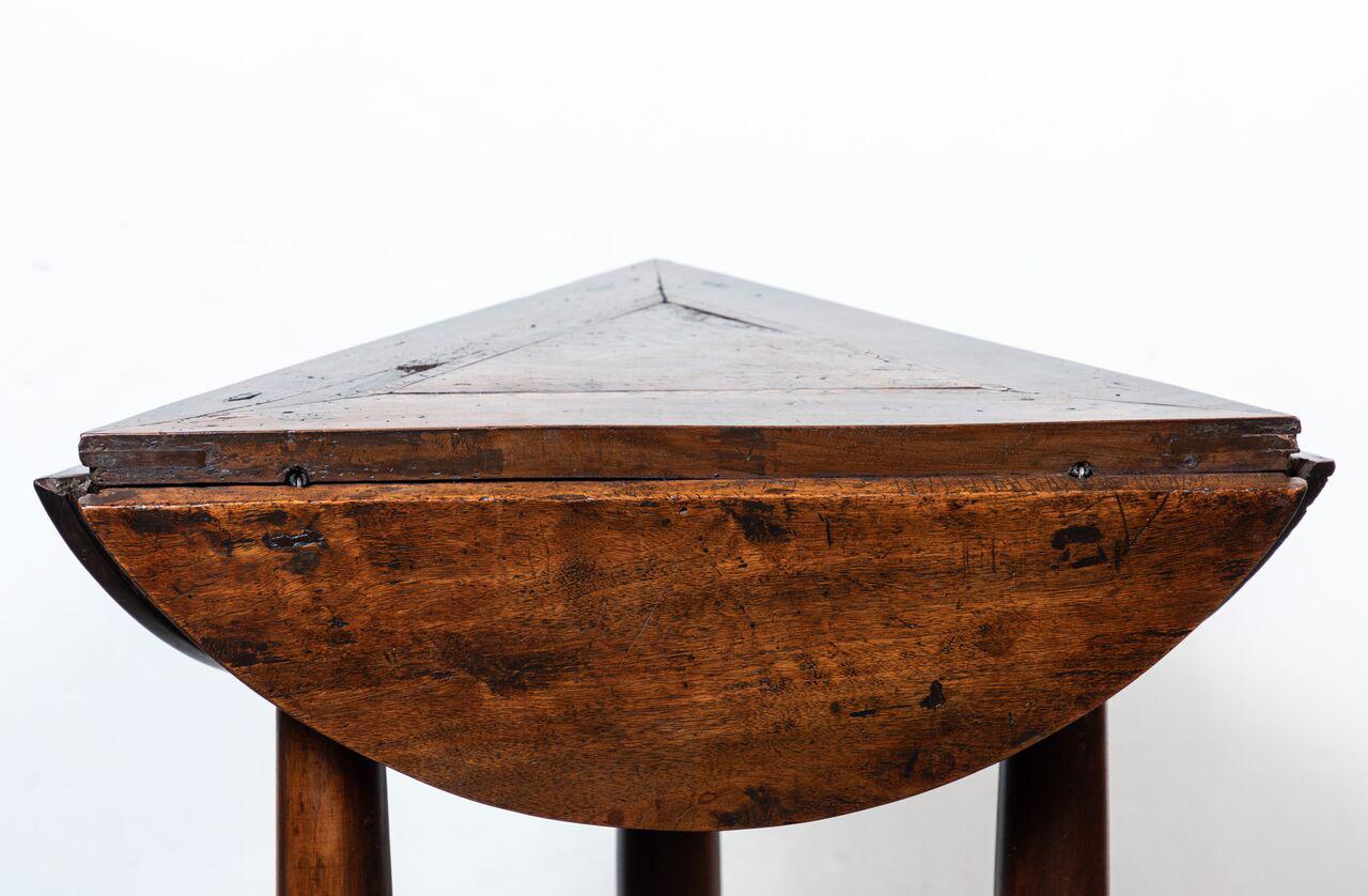 Unique, hand-carved, Italian, Baroque, walnut side table featuring three, rounded drop leafs atop pillars, mounted on a clipped corner, triangle base. The top inlaid with ebonized walnut parquetry.