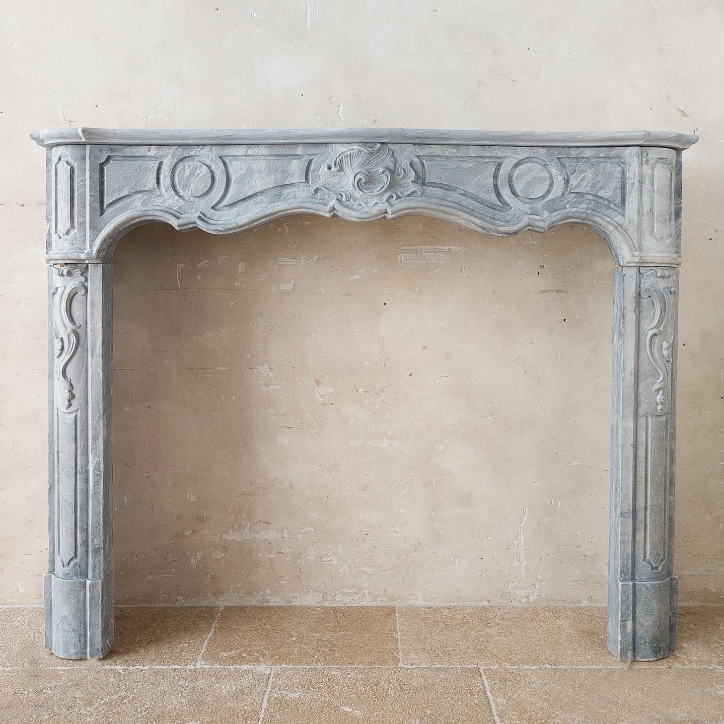 18th century Dutch Blue Turquin marble mantelpiece, in Régence Style with a Rococo shell ornament. This beautiful marble fireplace in soft grey tones originates from a Dutch canal house.

h 105.5 x w 133.5 x d 31 cm
opening: h 87 x w 104 cm