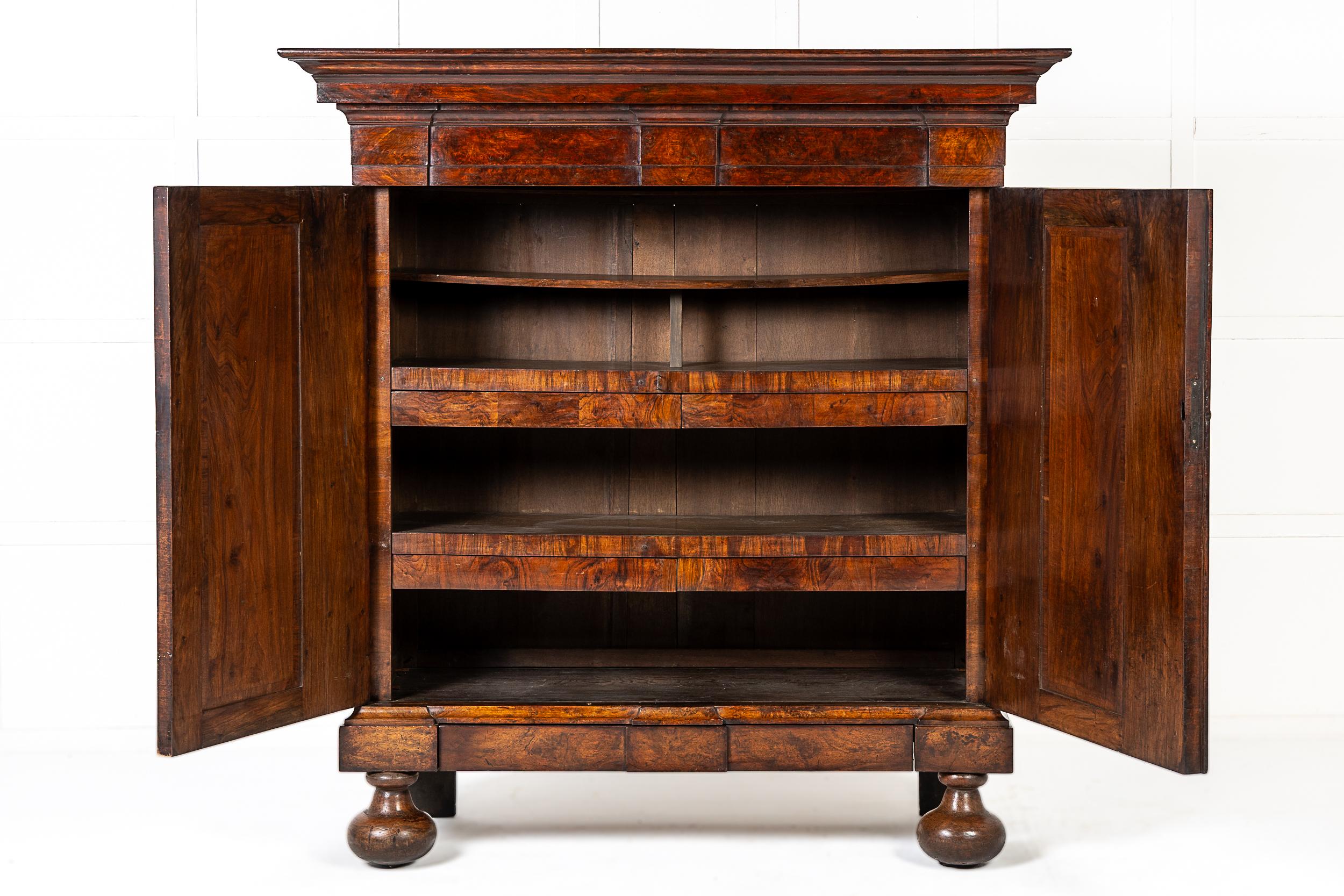 A Fine 18th Century Dutch Cabinet of Architectural Form in Finely Figured Burr Walnut.

This finely-proportioned piece is very architectural in style and features an overhanging pediment above a pair of panelled doors, veneered throughout in burr