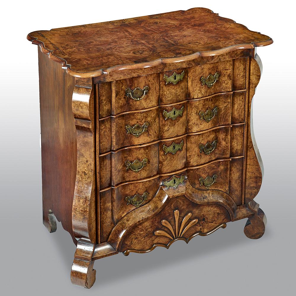 An exceptionally fine mid-18th century Dutch burr walnut commode, with superb original colour and patina, with quarter veneered rectangular serpentine shaped top above four waved graduated drawers with original brass handles, shaped apron, on