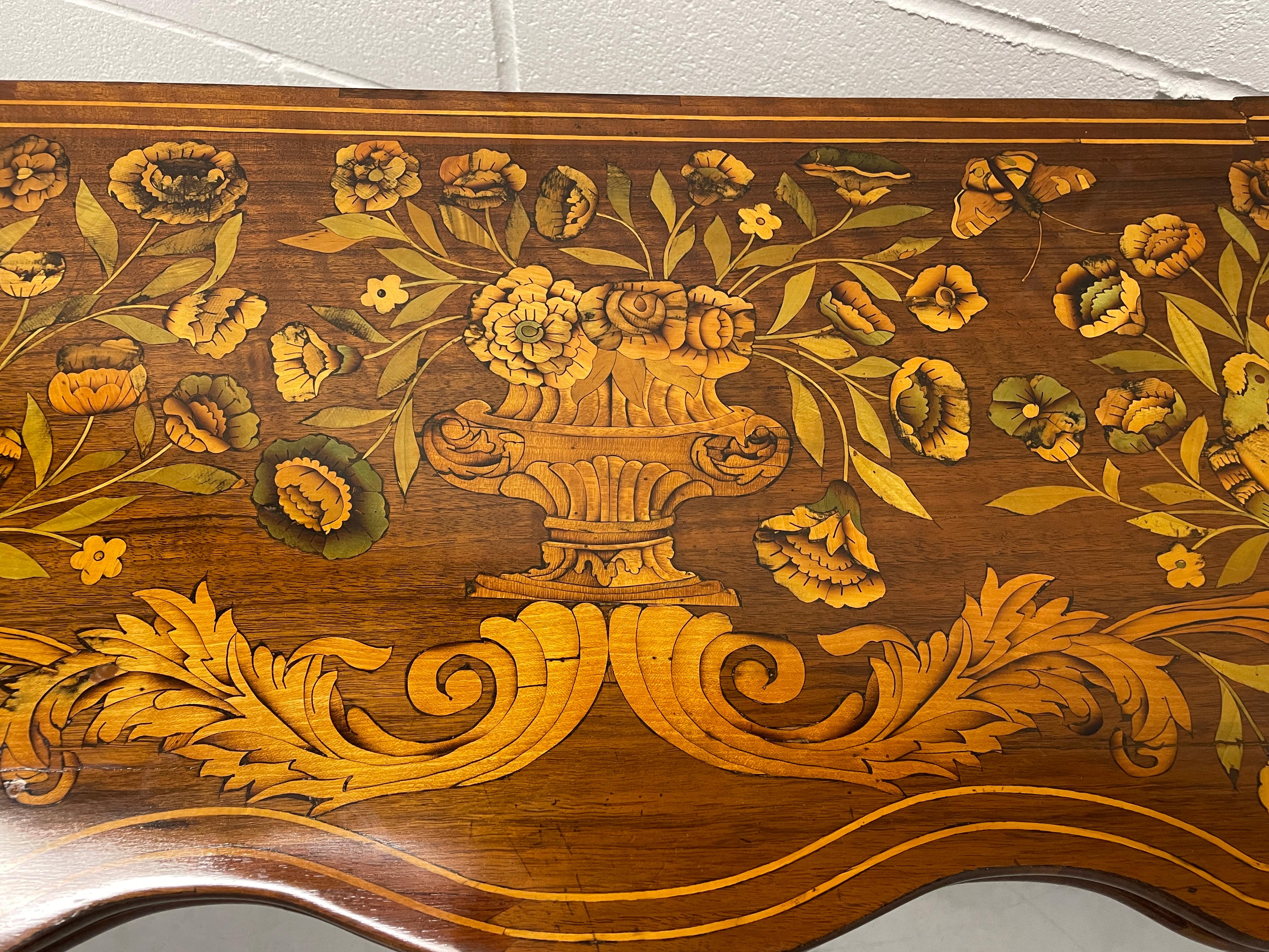 This unique card table dates back to the second half of the 18th century and comes from the Netherlands. The card table has a gorgeous marquetry on the top. Flowers and birds decorate this exquisite piece. You can easily use it as a console table in