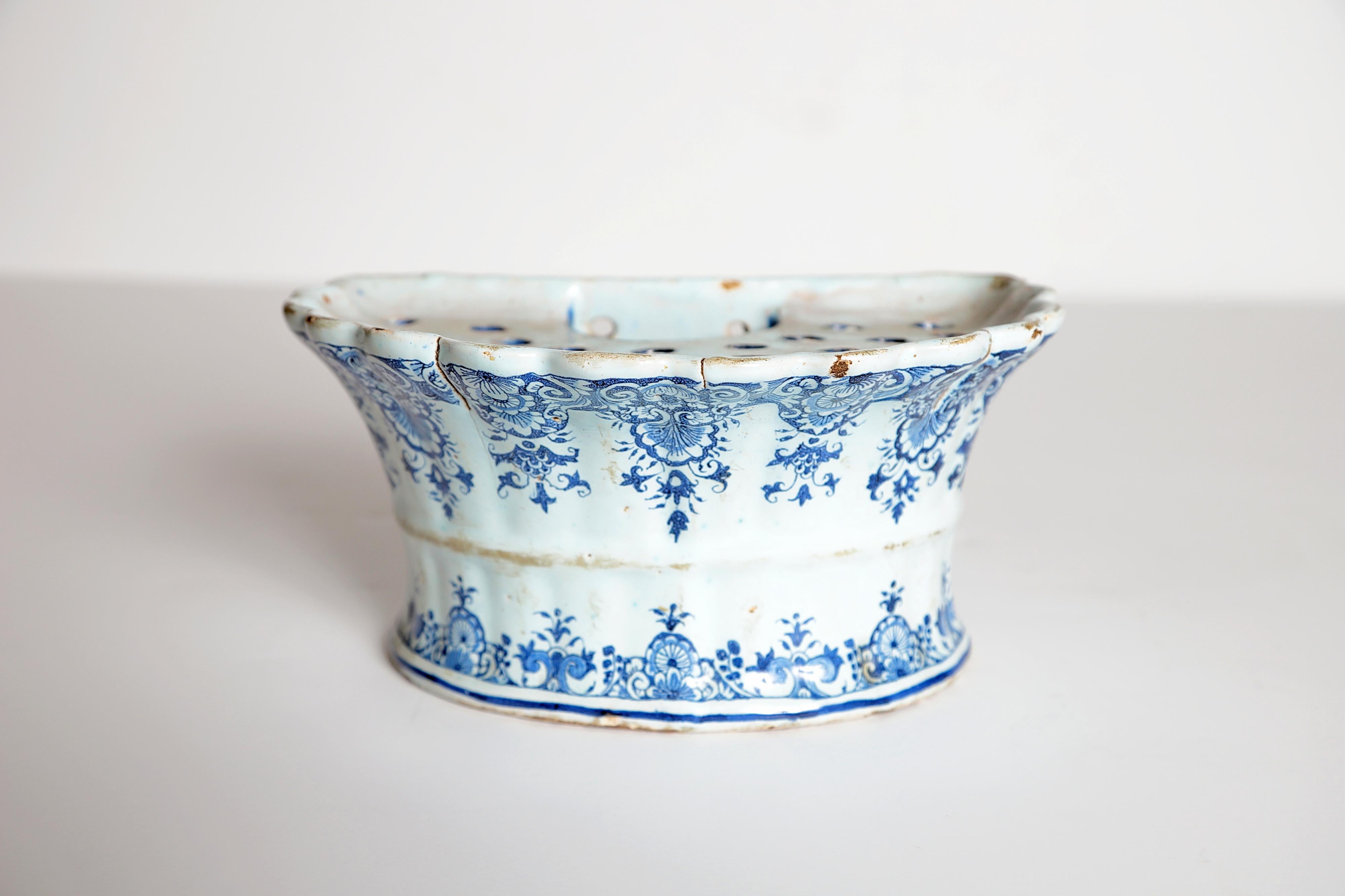 An 18th century Dutch delft hanging (wall mounted / wall pocket) bough pot of D-shaped fluted form. The bough pot features traditional hand painted blue and white floral decorations. Holes and water well on the top.