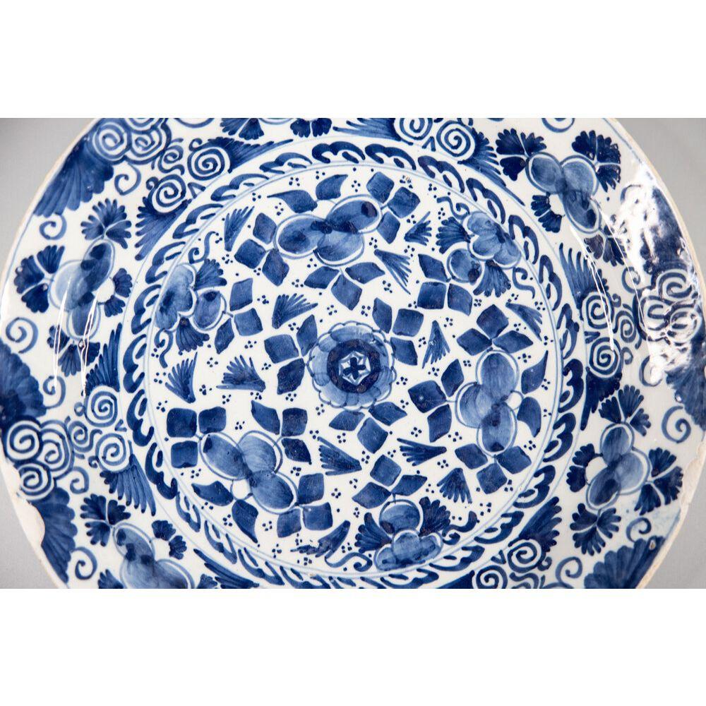 A large 18th-century Dutch Delft charger hand painted with a floral and foliate design in cobalt blue and white, circa 1750. This lovely large plate would be wonderful added to a collection, displayed on a wall, plate rack, or cabinet.

