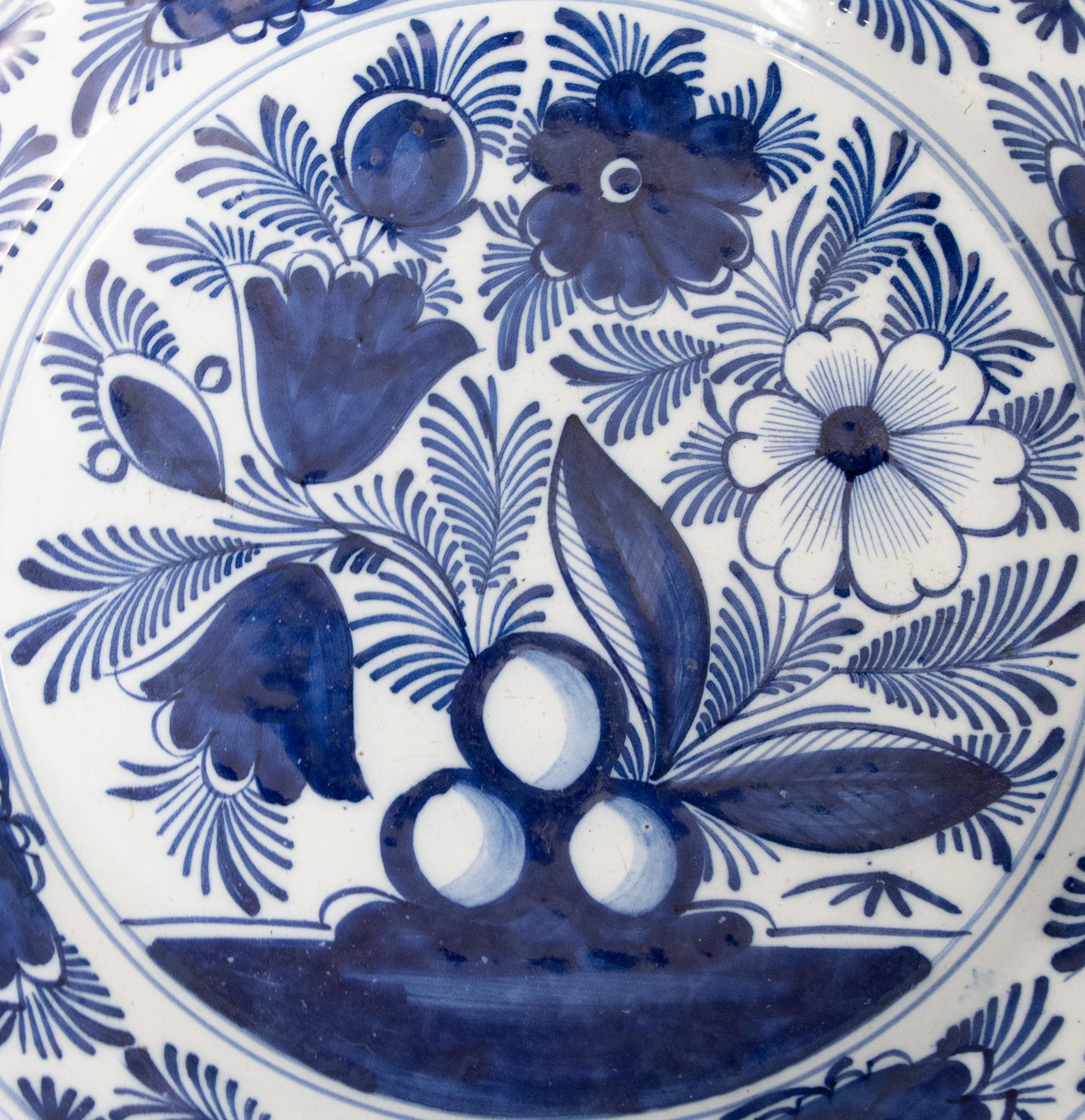 A large 18th-century Dutch Delft charger hand painted with a floral and foliate design in cobalt blue and white, circa 1750. This lovely large plate would be wonderful added to a collection, displayed on a wall, plate rack, or