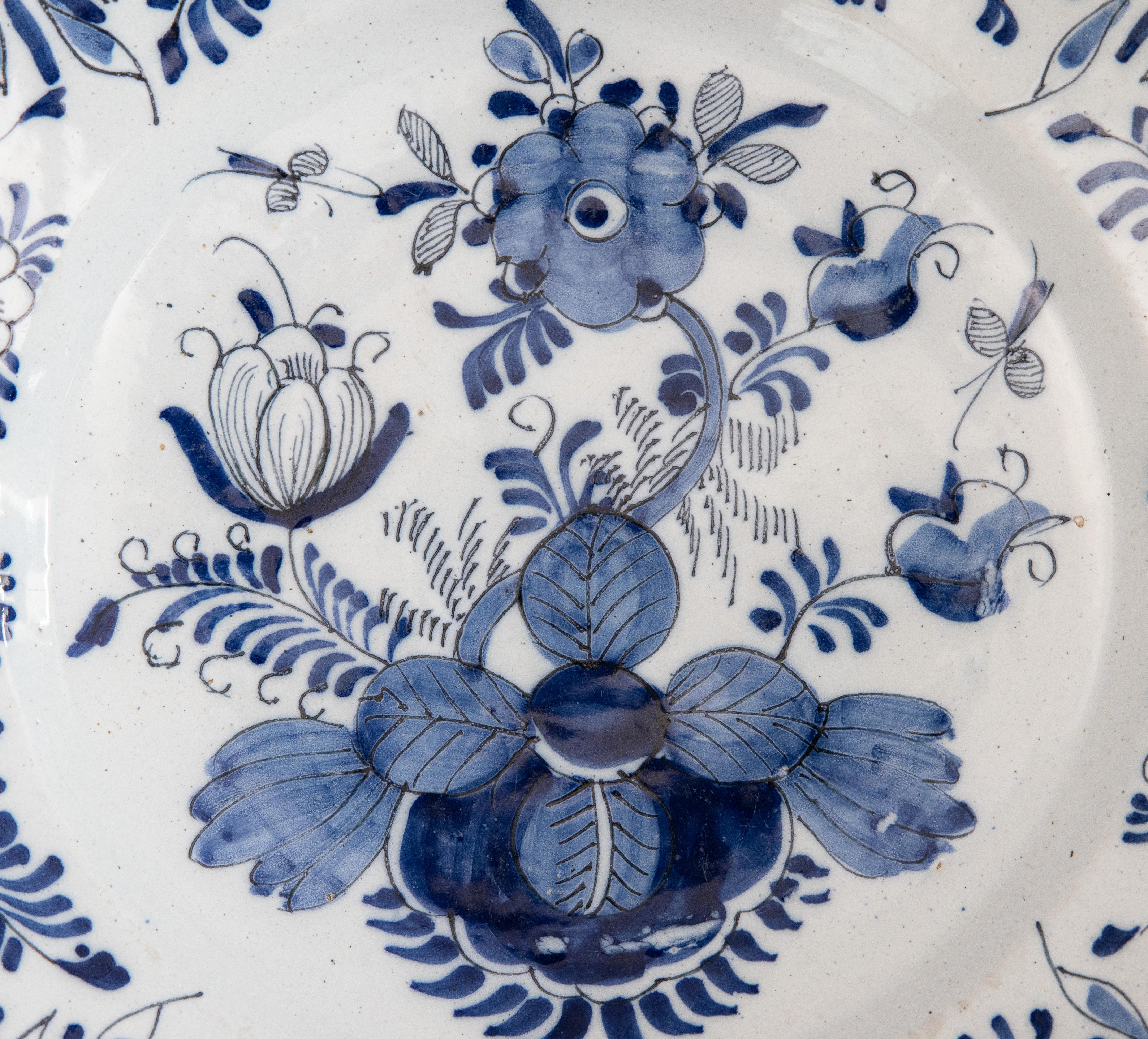 Grand chargeur Delft hollandais du XVIIIe siècle, peint à la main d'un motif floral et feuillu avec des insectes en bleu de cobalt et blanc, vers 1750. Cette belle grande assiette serait merveilleusement ajoutée à une collection, exposée au mur, sur