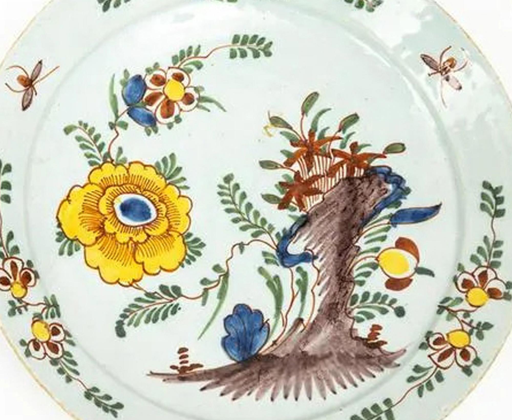 Dutch Delft Polychrome Chinoiserie Plate

The Dutch Delft pancake plate is colorfully painted with a Chinoiserie design of rockwork with flowering plants growing from it including a large yellow leafed flower.  The border with sprigs and