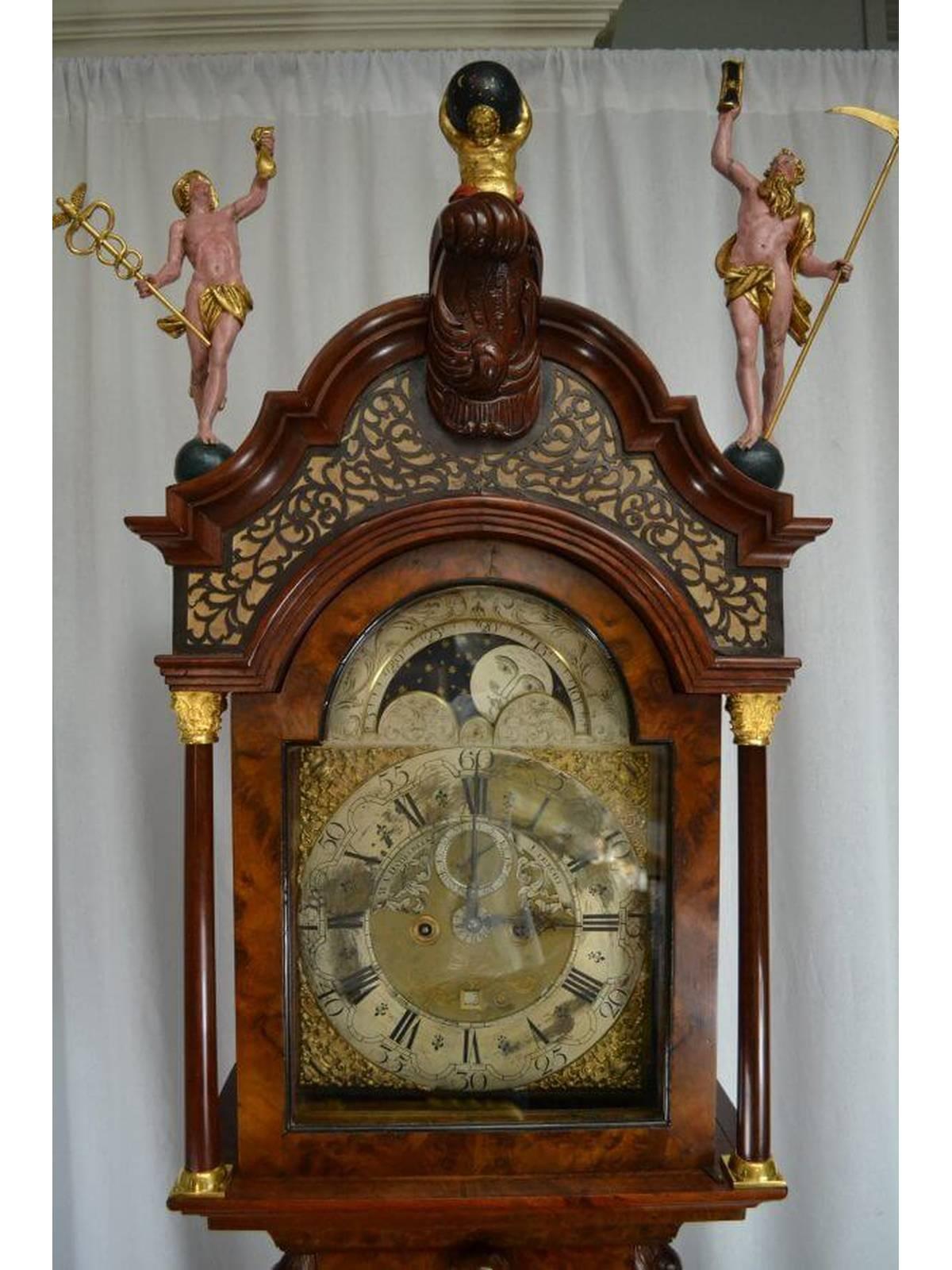 A walnut, burr-walnut and inlaid longcase clock by W.V. Dadelbeek, Utrecht. The case of typical form, painted and parcel gilt wood figural finials of Atlas, Father Time and Mercury. 

The silvered brass dial with engraved arch depicting the moon