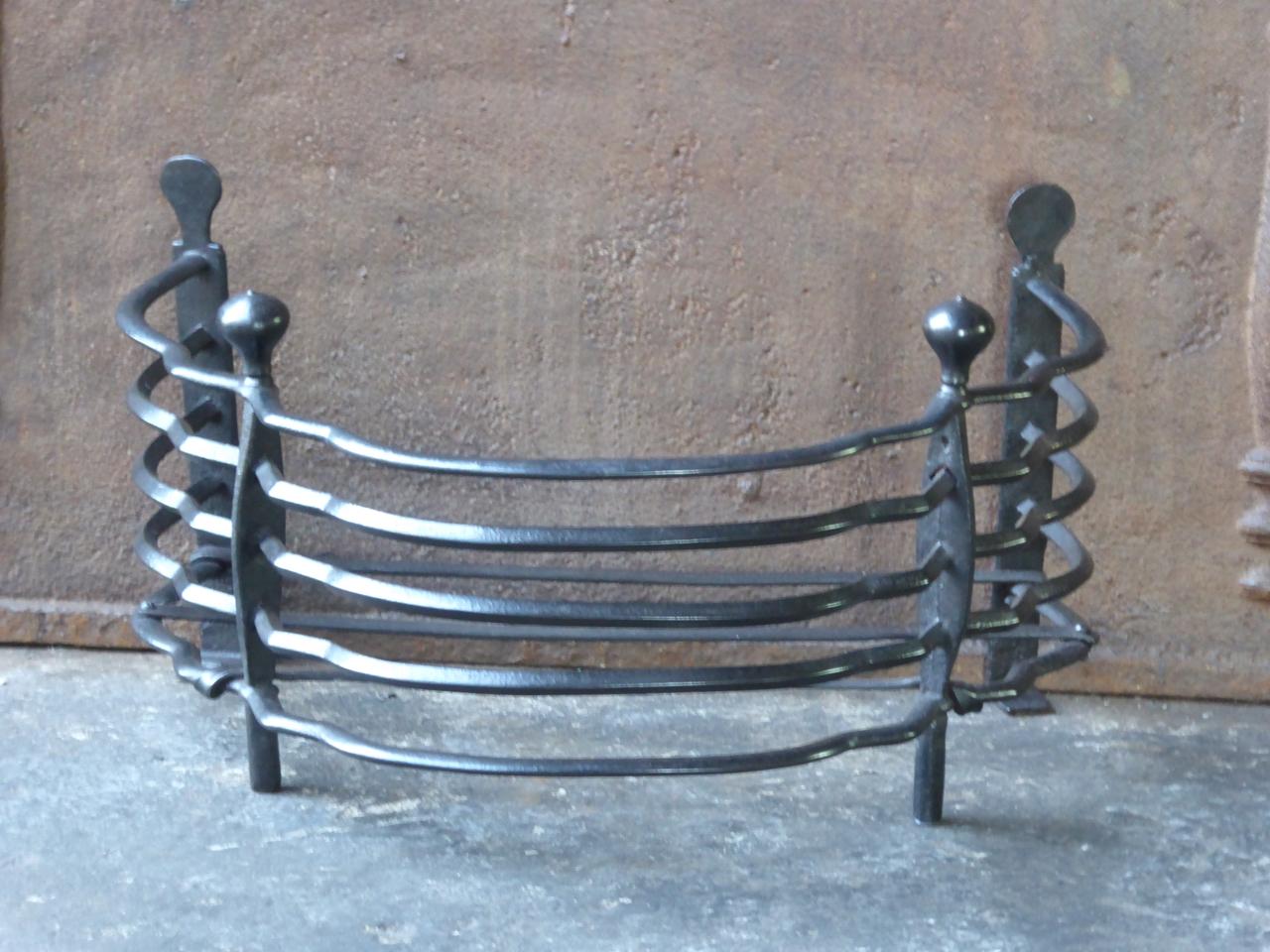 Beautiful Dutch 18th century Louis XV fireplace grate. The grate is made of wrought iron and has a black patina. The grate is in a good condition and is suitable for use in the fireplace.