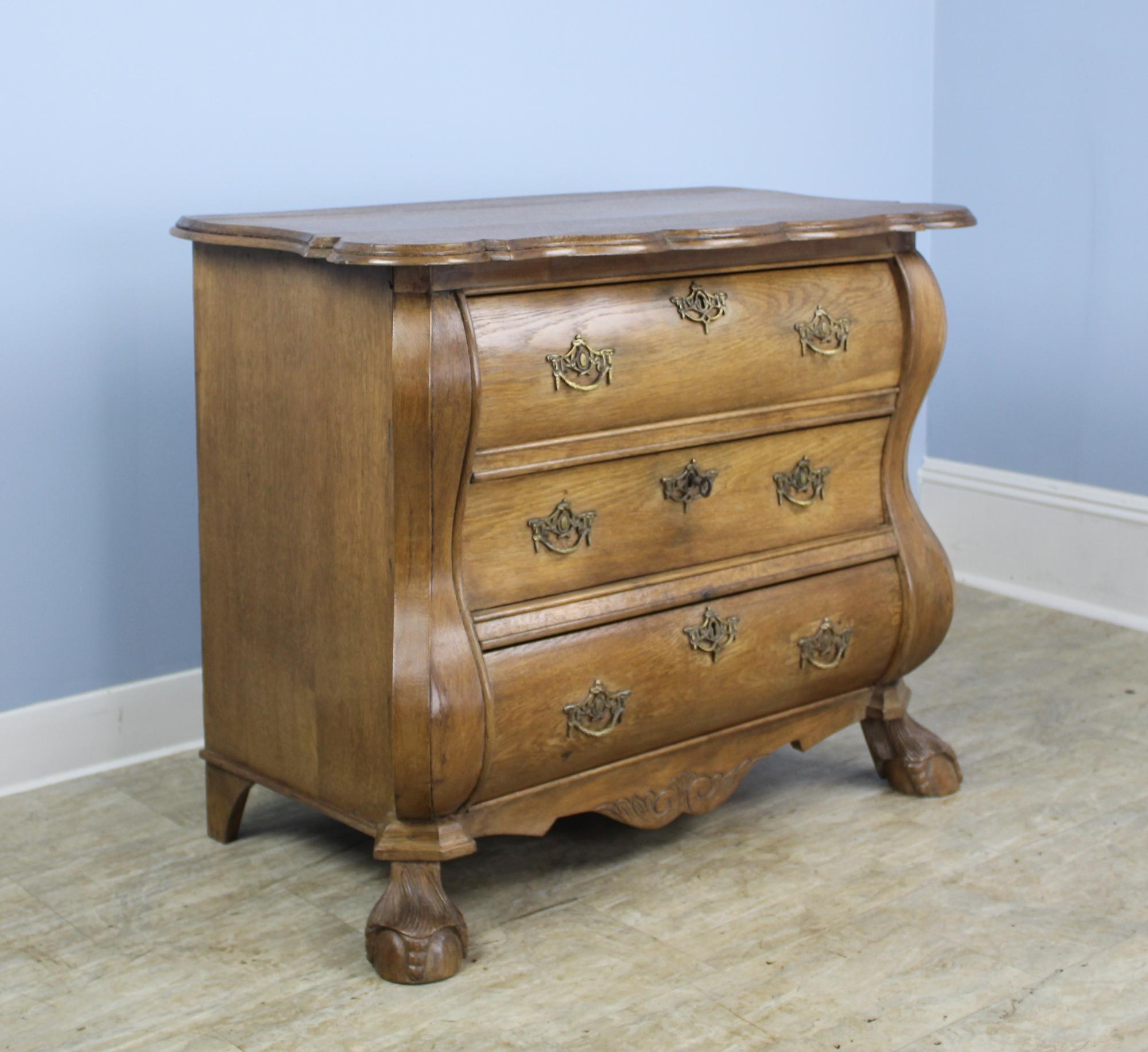 Fabulous early Dutch bombe chest or commode, grand in presence. This four drawer bureau is made of polished oak with a beautiful color and rich patina. Details of note include all original handles, shaped and decoratively carved apron on the front,