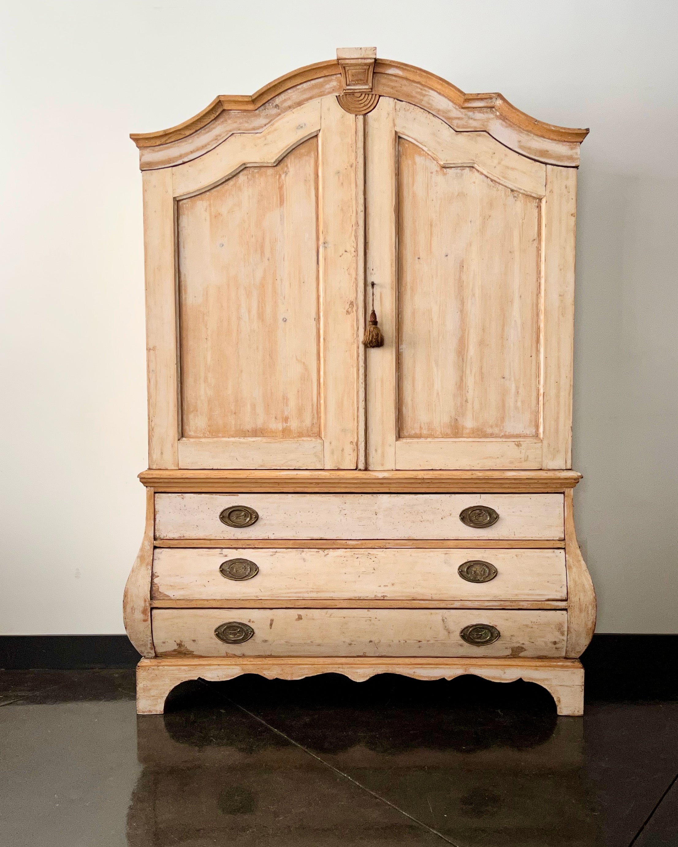 18th century Dutch in original painted oak two peace cabinet with simply carved unusual crest. The double paneled door upper cabinet sits atop three bombé drawers with beautiful decorative original bronze hardwares. Scalloped skirt with carved