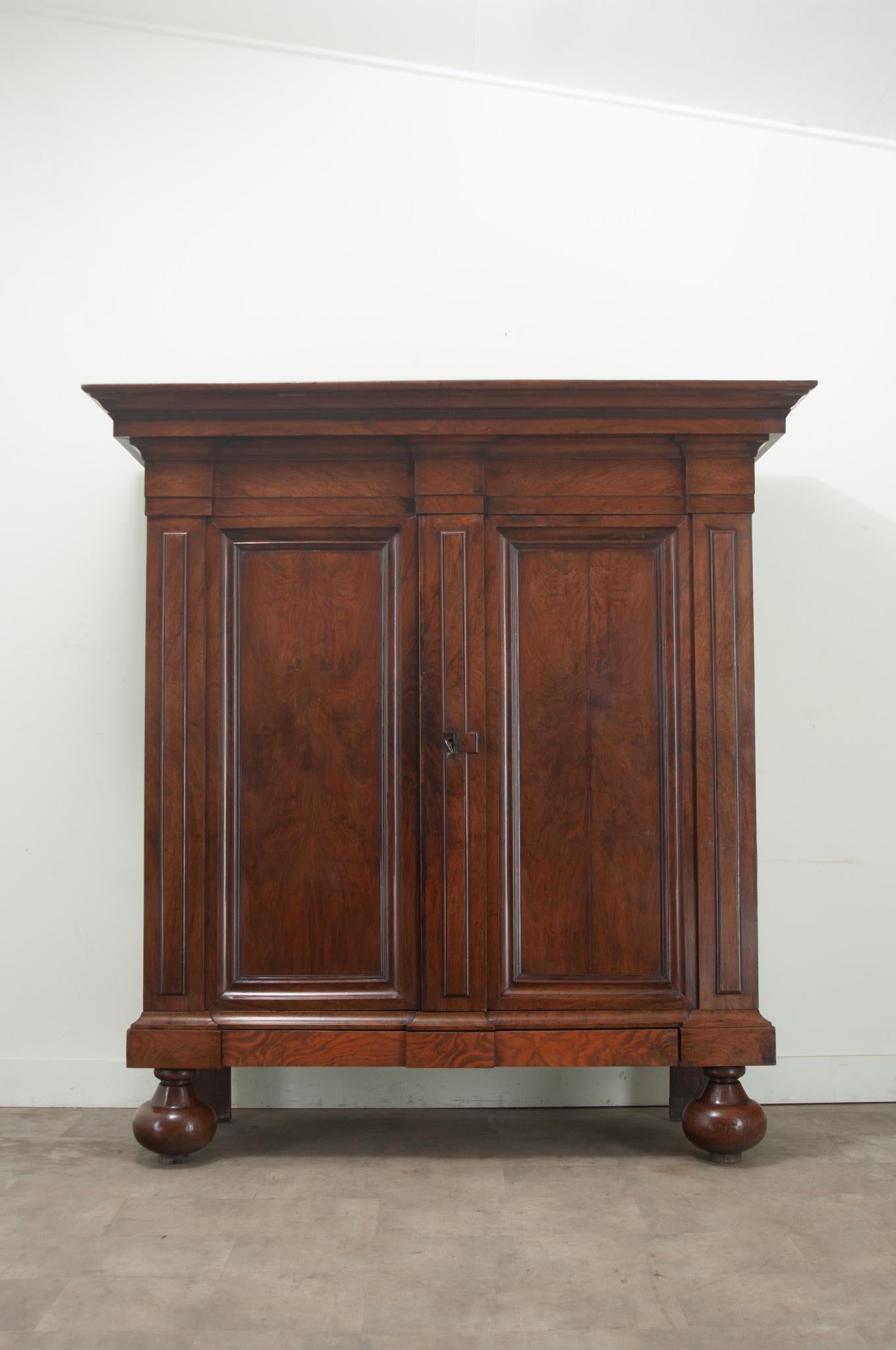 A solid walnut Dutch cabinet made in the Renaissance period. This substantial antique is hand made of solid beautifully figured walnut and makes quite the presence. Two tall paneled doors have a unique sliding key plate with a functioning lock and