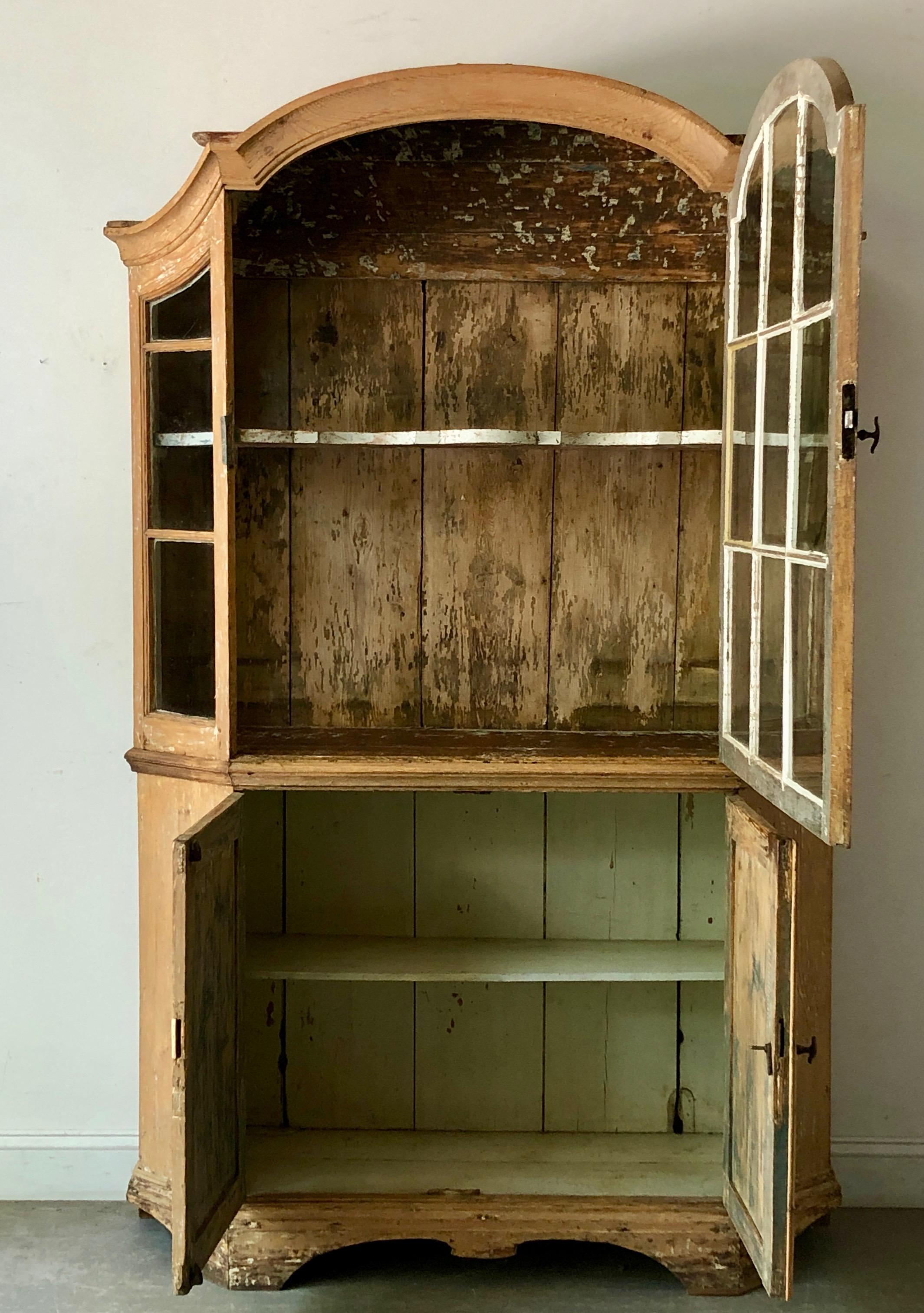 A very handsome 18th century Dutch cabinet vitrine in impressive scale with original hand blown glass, remnants of most original patinated color, beautifully shaped/scalloped interior shelve, arched pediment cornice and panelled doors.