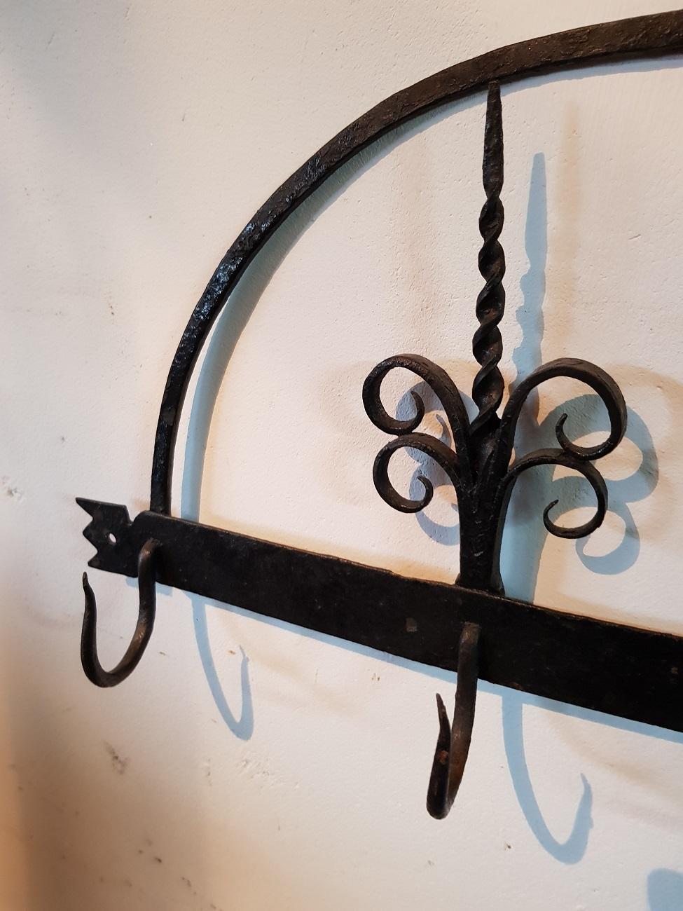 18th century Dutch wrought iron wall rack for fireplace tools, truly a beautiful piece of craftsmanship.

The measurements are,
Depth 5 cm/ 1.9 inch.
Width 60 cm/ 23.6 inch.
Height 27 cm/ 10.6 inch.
