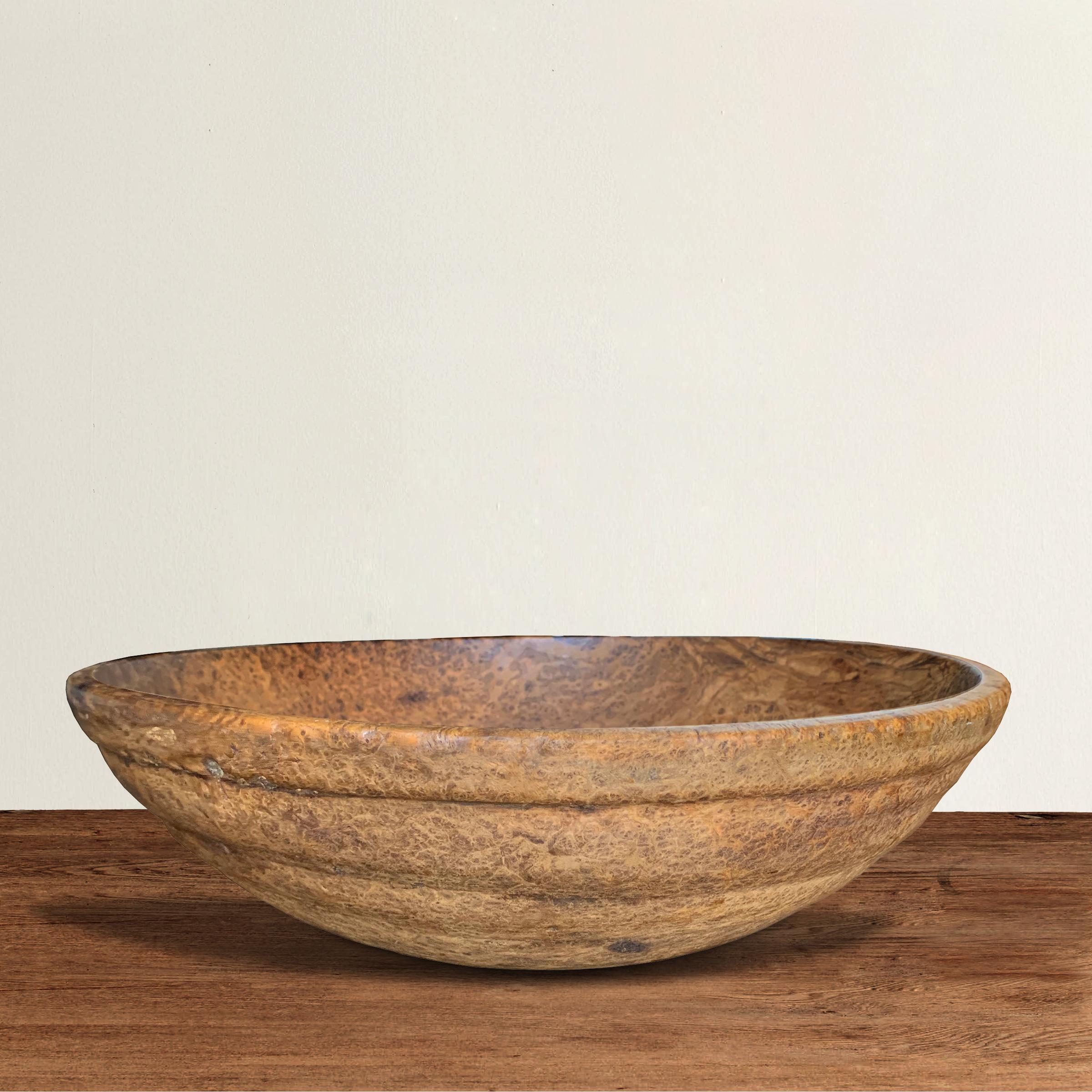 An incredible 18th century early American ash burl bowl from New England, possibly New York, with a heavy lip, spiral-cut ribbed sides, and an unbelievable surface texture and well-worn patina, the result of over two centuries of use.