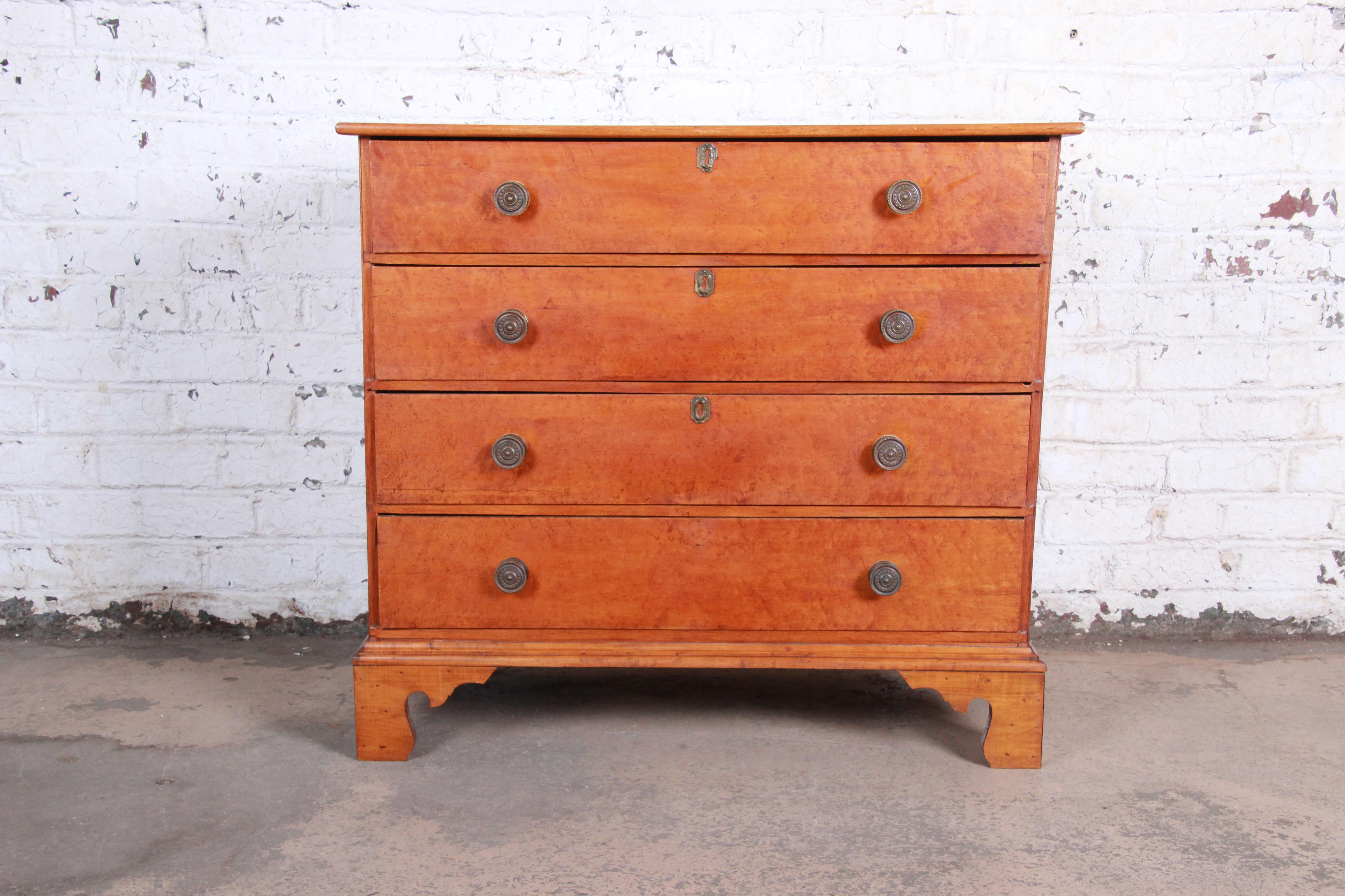 A gorgeous Early American bird’s-eye maple four-drawer chest of drawers, circa 1780. The dresser features stunning maple wood grain and a classic Chippendale style. It offers good storage, with four dovetailed drawers. The interior wood is pine. The