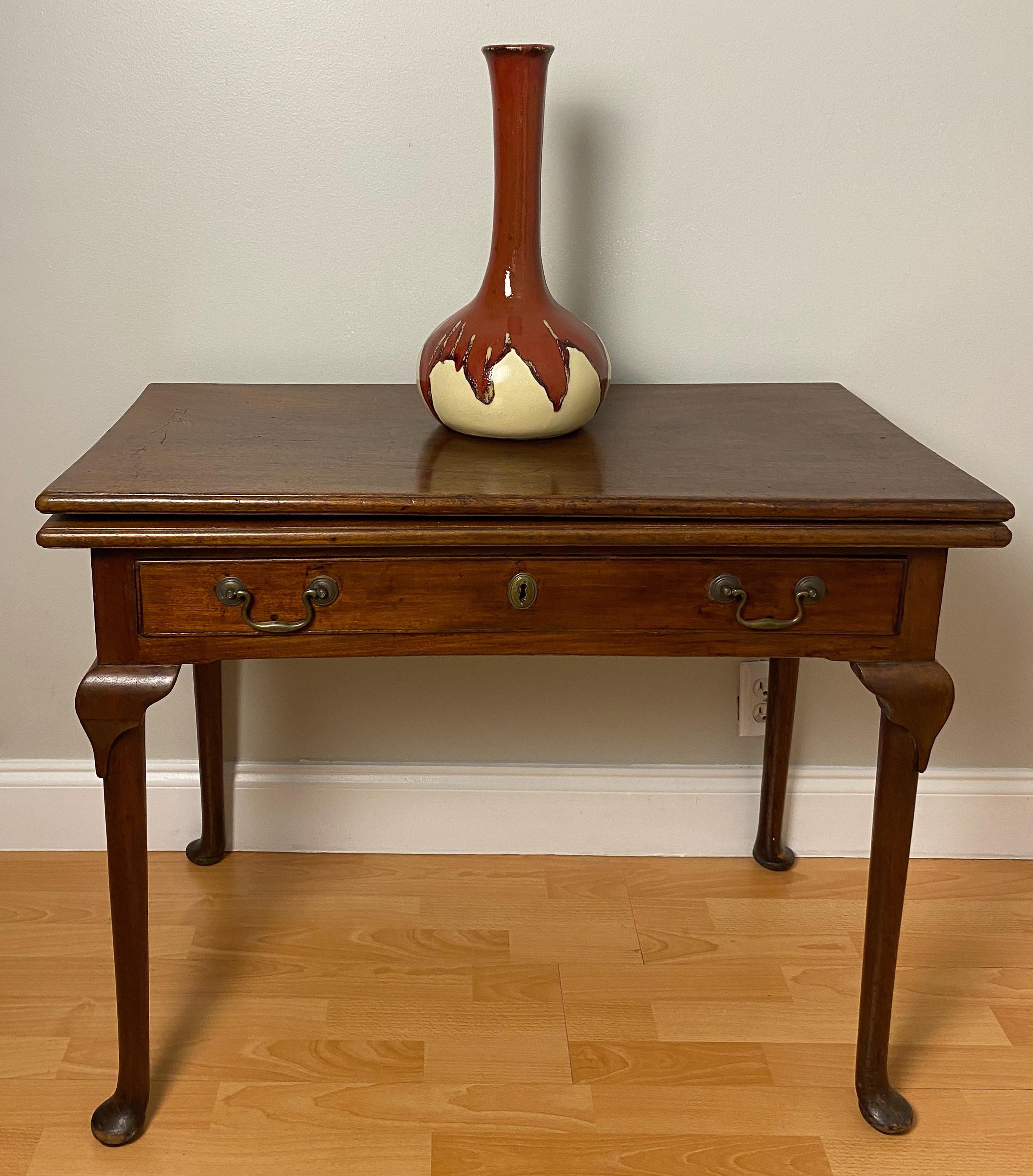 A fine early American Federal Chippendale style mahogany card table with rectangular flip top bearing a molded edge. The top is supported by a frieze drawer with period brass pull. Makes a wonderful entry or console table.

A gate leg opens to