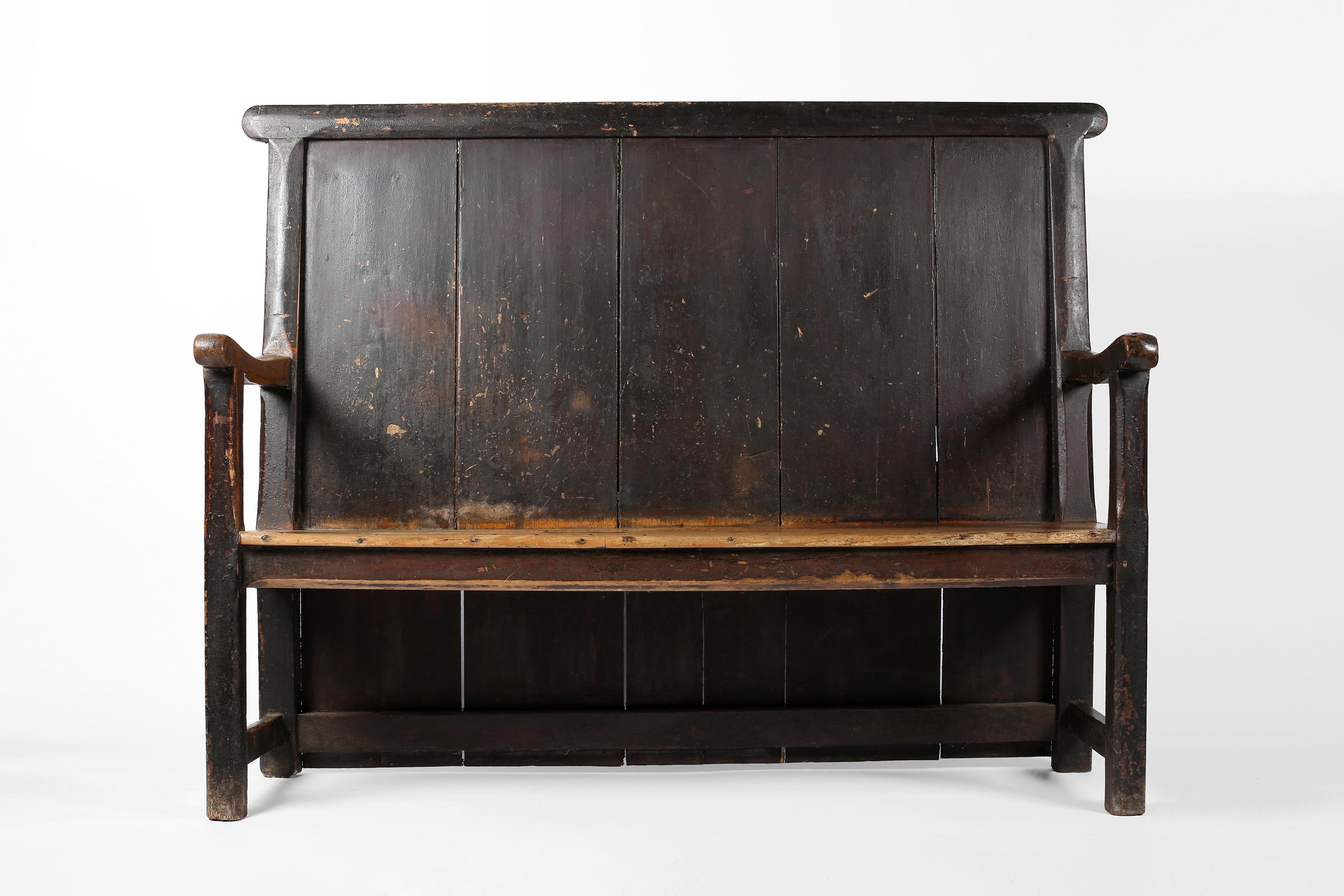 A large, late 18th century carved elm West Country settle, with original paint and attractive wear to the seat and armrests. North Devon, England, c. 1780.