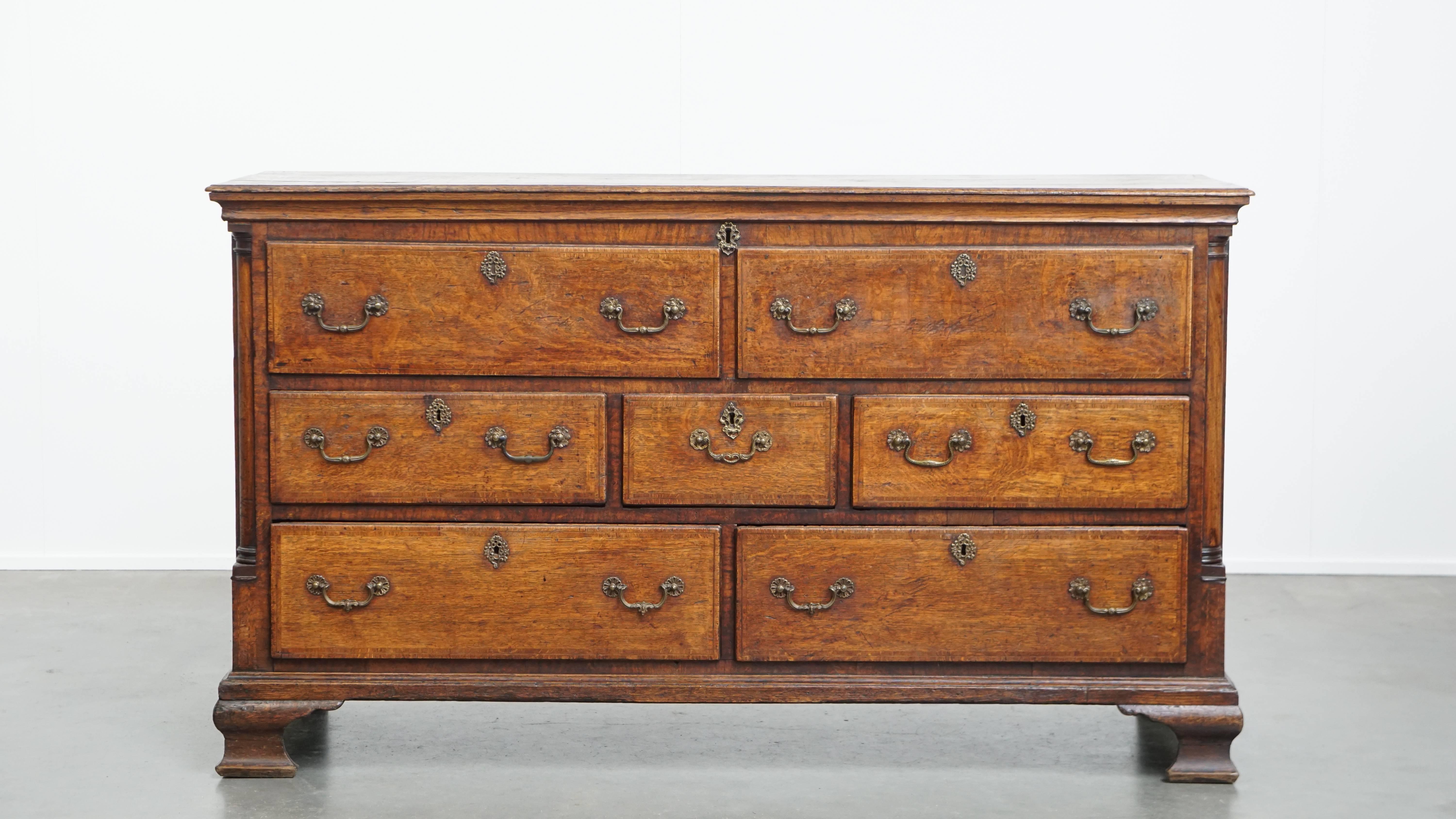 Offered here is this stunning, characterful 18th-century English antique sideboard, also known as a “mule chest.” 

This exceptional 18th-century English piece is a true mule chest—an antique gem full of charm and character, perfect for the true
