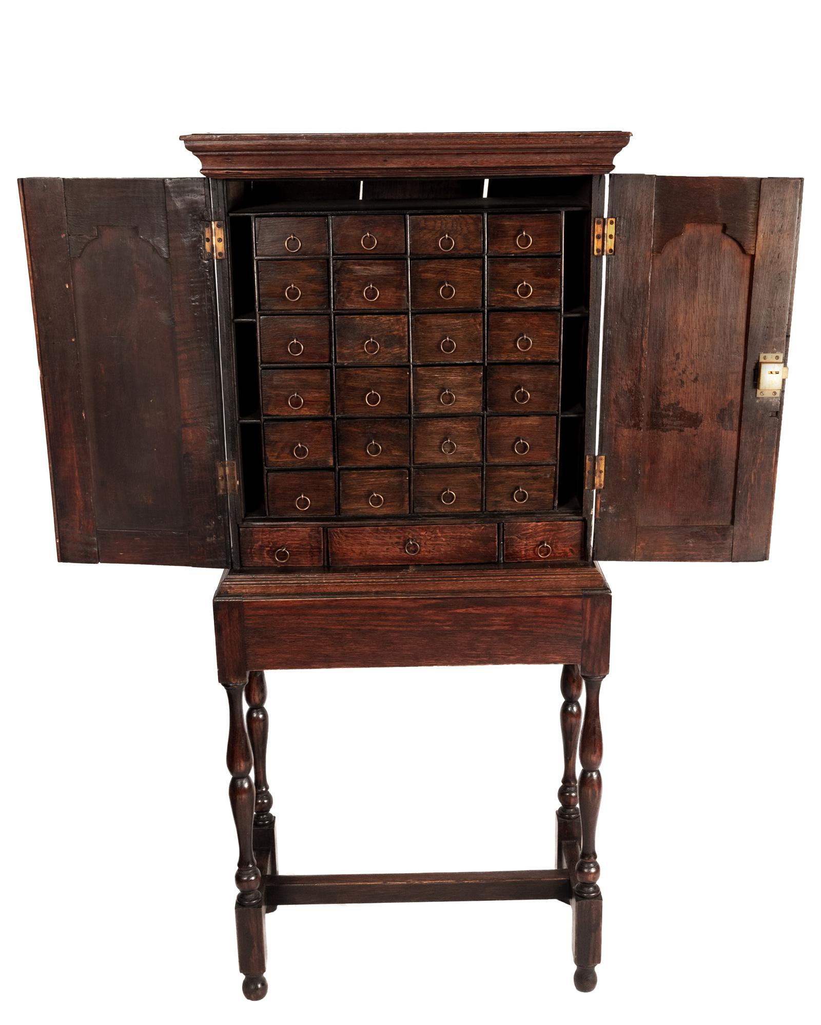 An 18th century English oak apothecary cabinet on stand.
