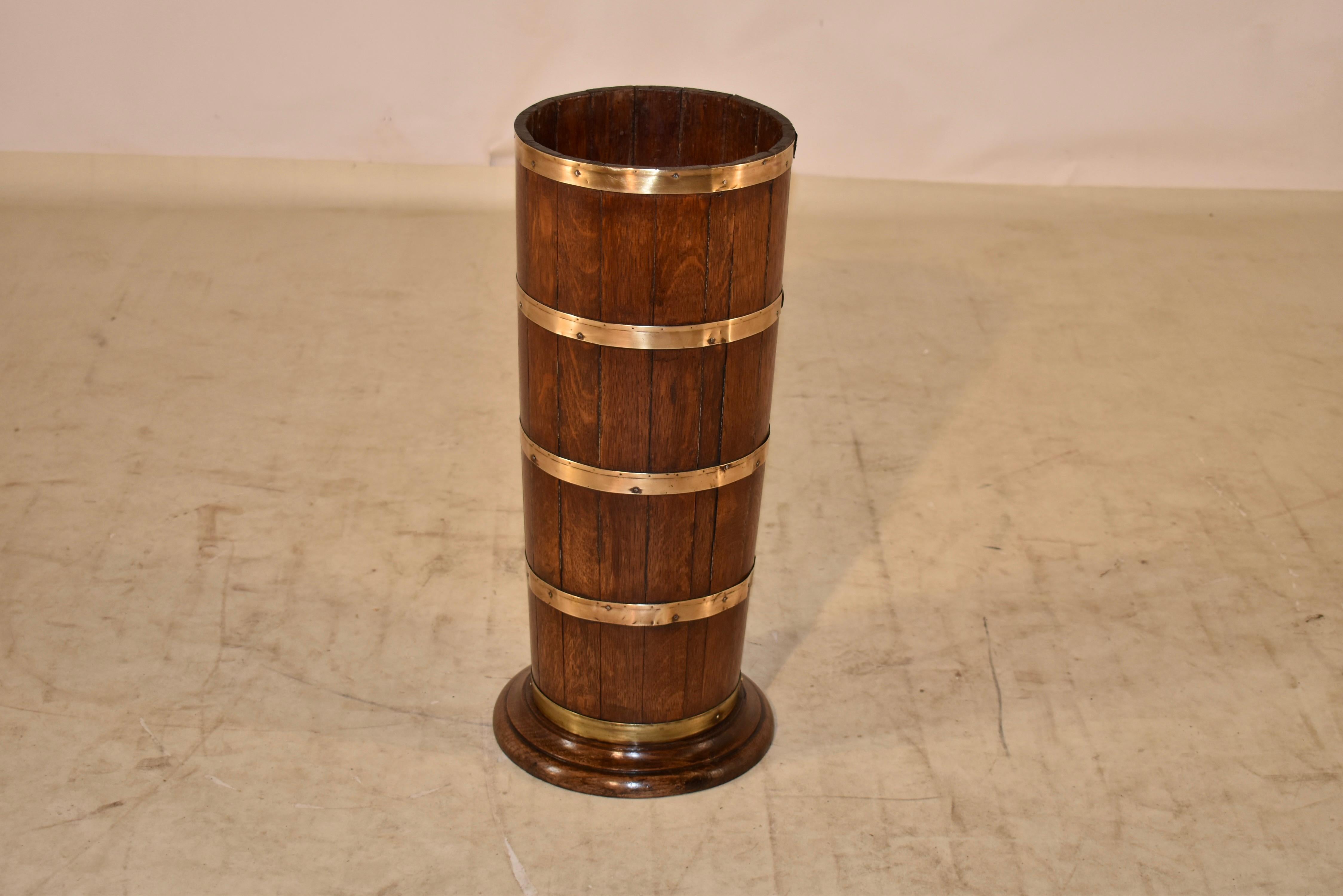 18th Century oak umbrella or cane stand strapped in hand made brass straps. There is a drip tray at the bottom for wet umbrellas. Classic and clean form and construction.