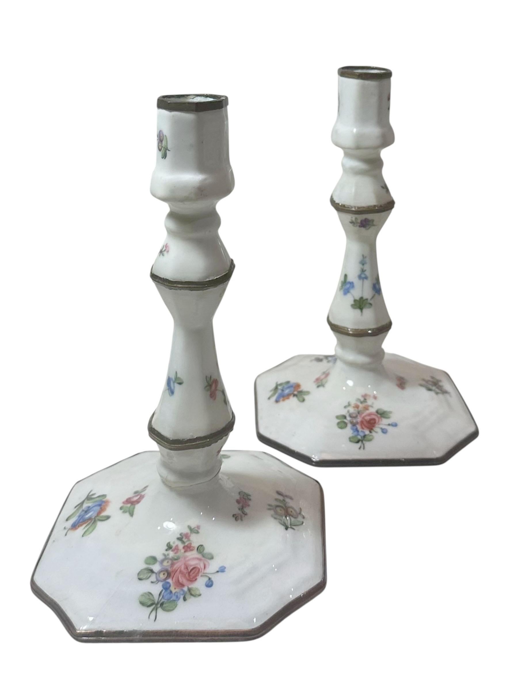 Paire exquise de chandeliers en émail de Battersea, datant du 18e siècle, vers 1760-1770. Ces rares chandeliers sont finement travaillés et magnifiquement décorés de motifs floraux peints à la main dans des émaux vibrants, chaque fleur étant