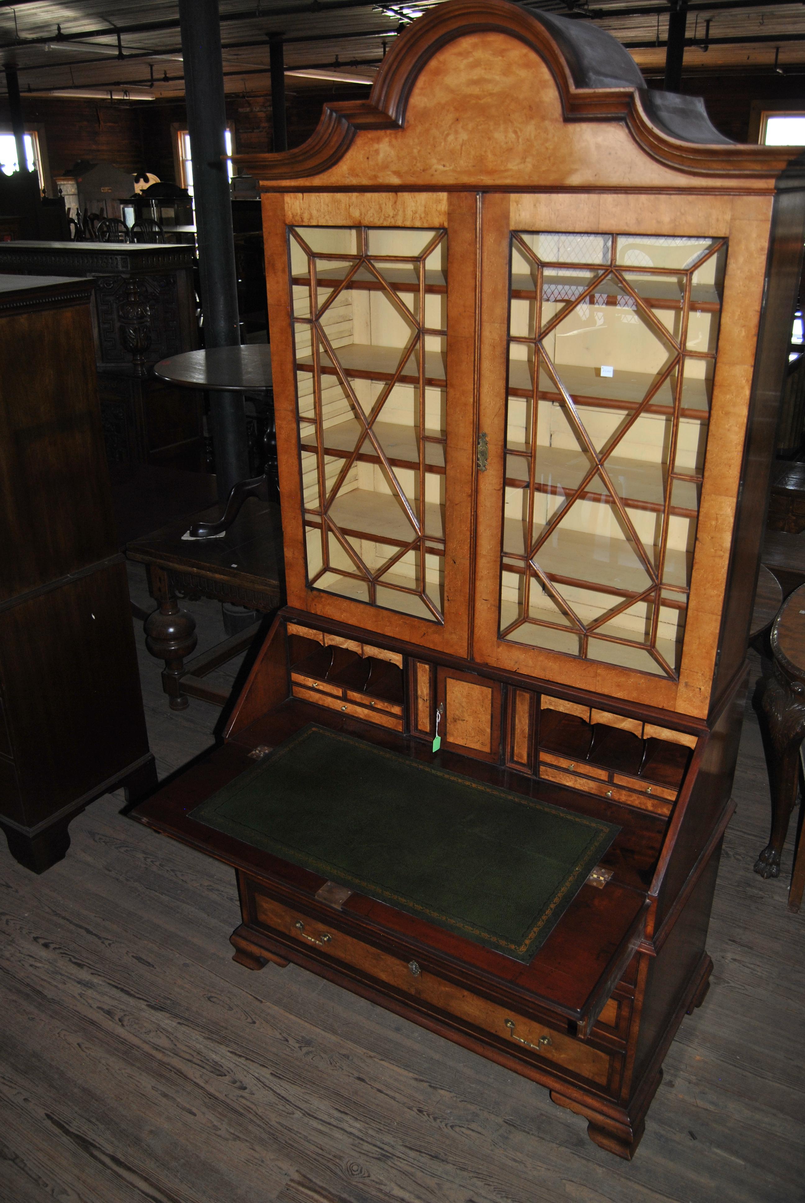 This is a bookcase secretary / bureau bookcase made in England, circa 1790. It has a beautifully shaped top with a heavy, layered crown molding. There is a pair of beautifully glazed windows in the upper doors. There are four adjustable shelves