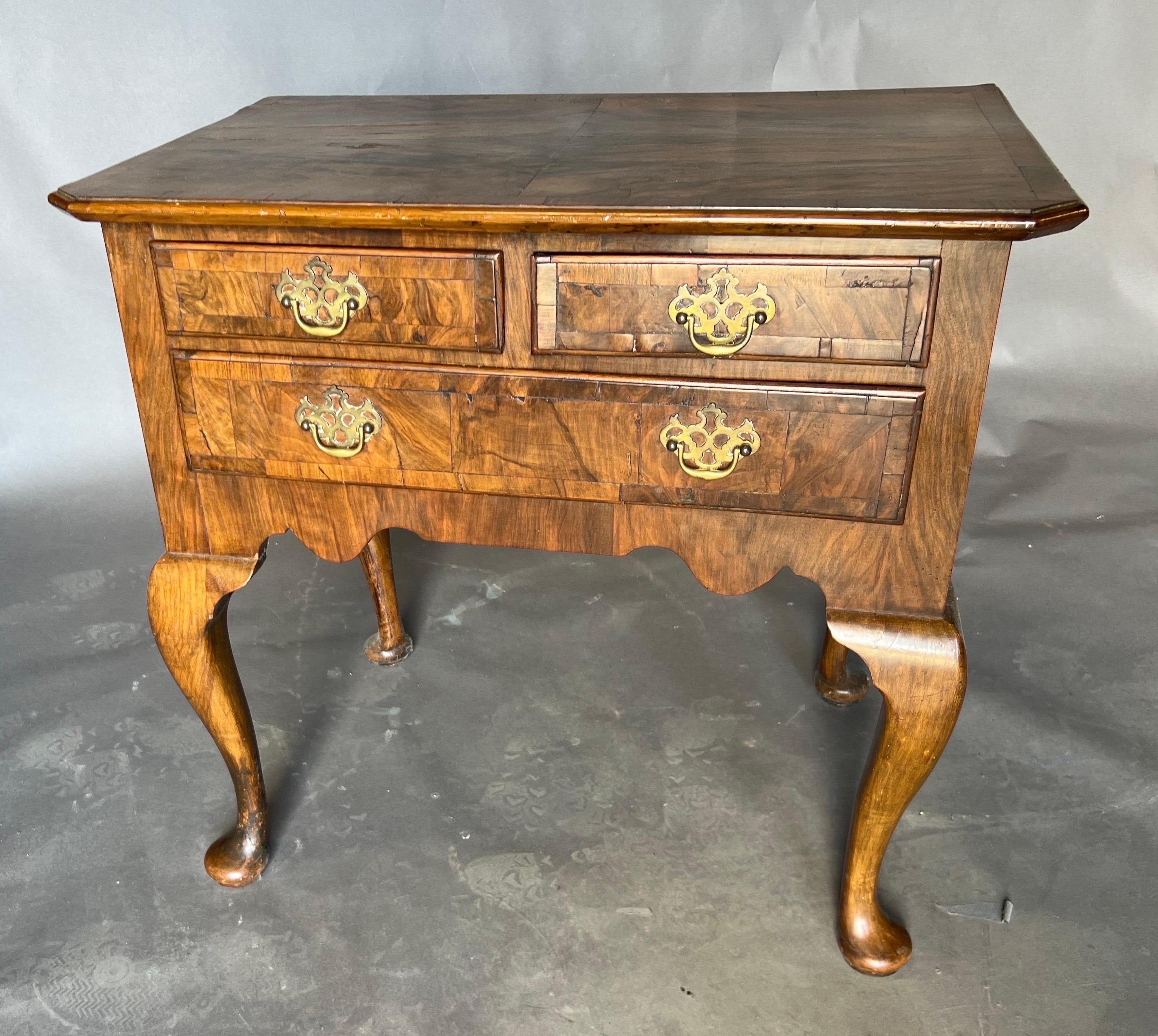 Great little 18th century English burl walnut and oak lowboy on cabriole legs and pad feet. This beauty features an overhanging top, two smaller drawers over one larger drawer and great color and patina. 