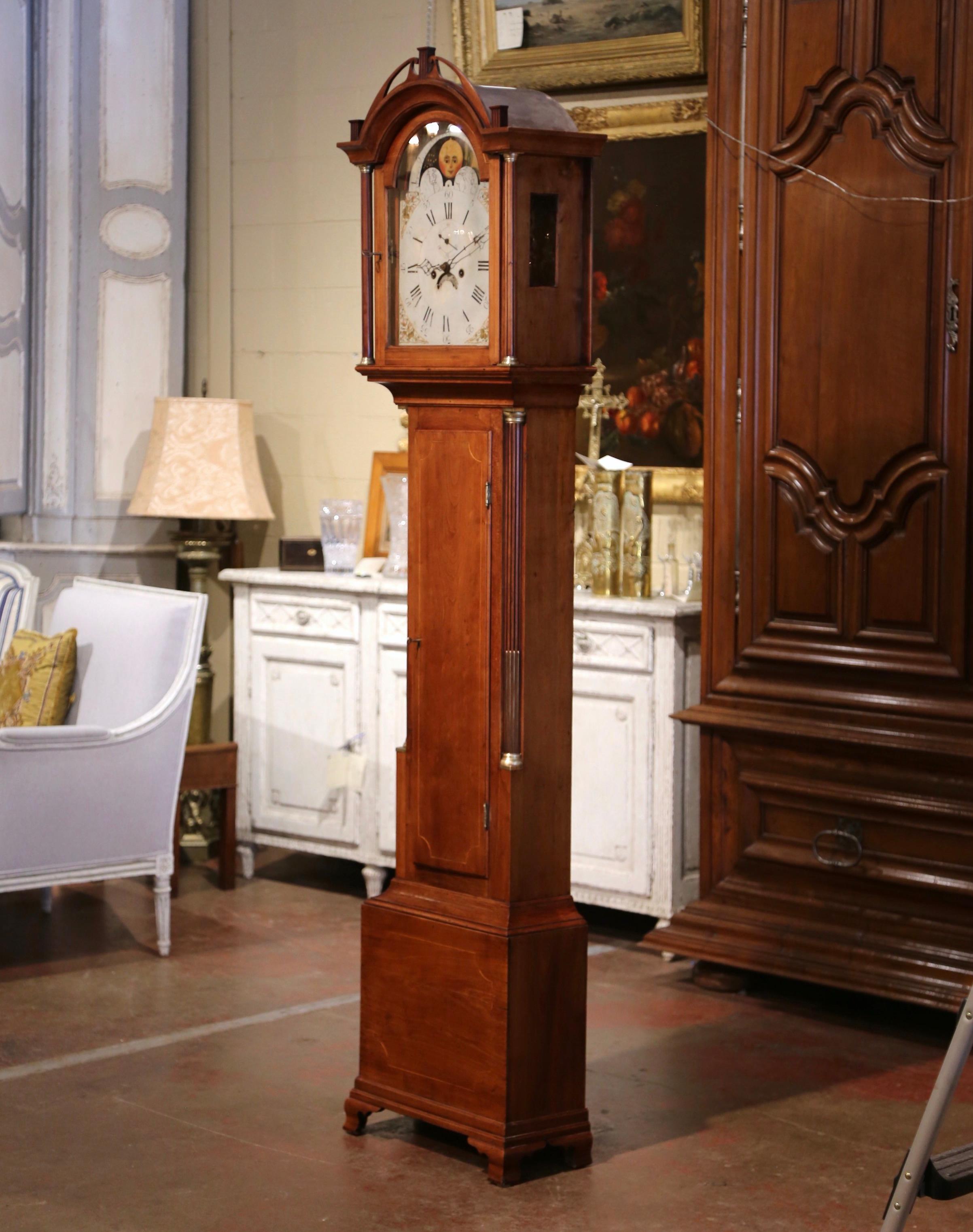 This elegant, antique Chippendale grandfather clock was carved in England, circa 1780. The tall case clock with bonnet top is decorated with side columns embellished with brass mounts. The clock movement is original with pendulum, weighs and key.