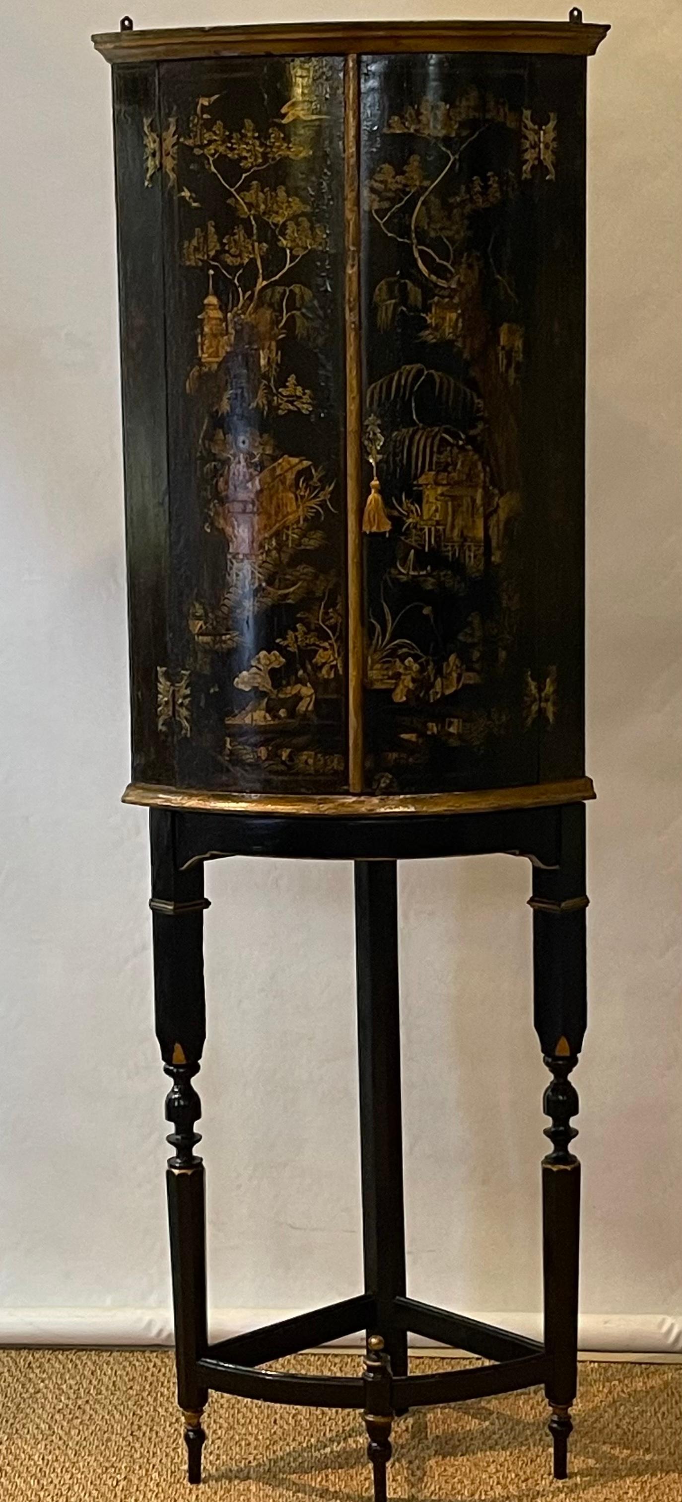 A late 19th C. English Chinoiserie decorated black lacquer corner cabinet on later ebonized and gilt decorated stand.