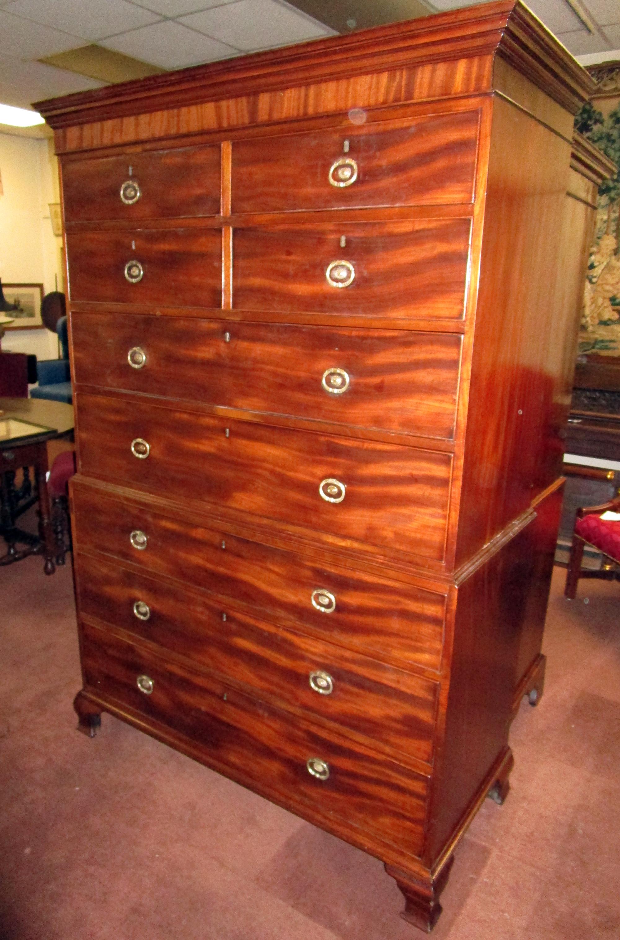 Fine large size English mahogany Chippendale chest on chest. Features include ogee bracket feet, original brasses, molded top and book-matched mahogany drawer fronts. The two sets of double drawers at the top are an unusual feature. 
Note dovetail