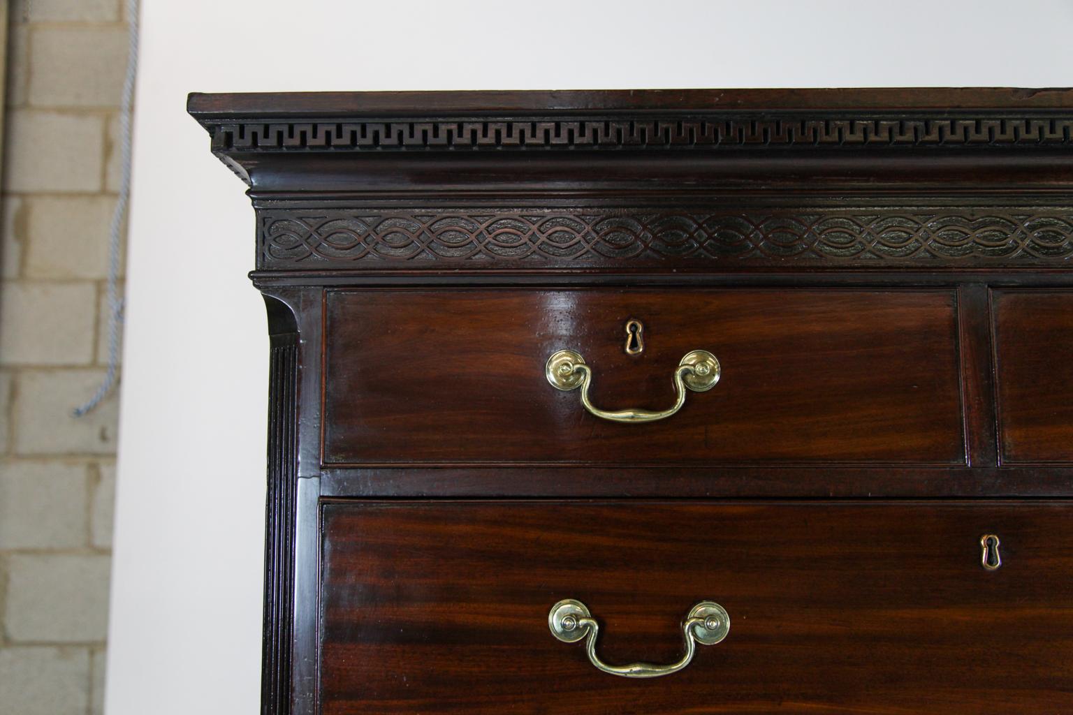 18th century English Chippendale mahogany chest on chest, upper section with “wall of Troy” dentil cornice above blind fretwork frieze, two over three drawer arrangement, the lower section with brushing slide over three graduated drawers, on slender