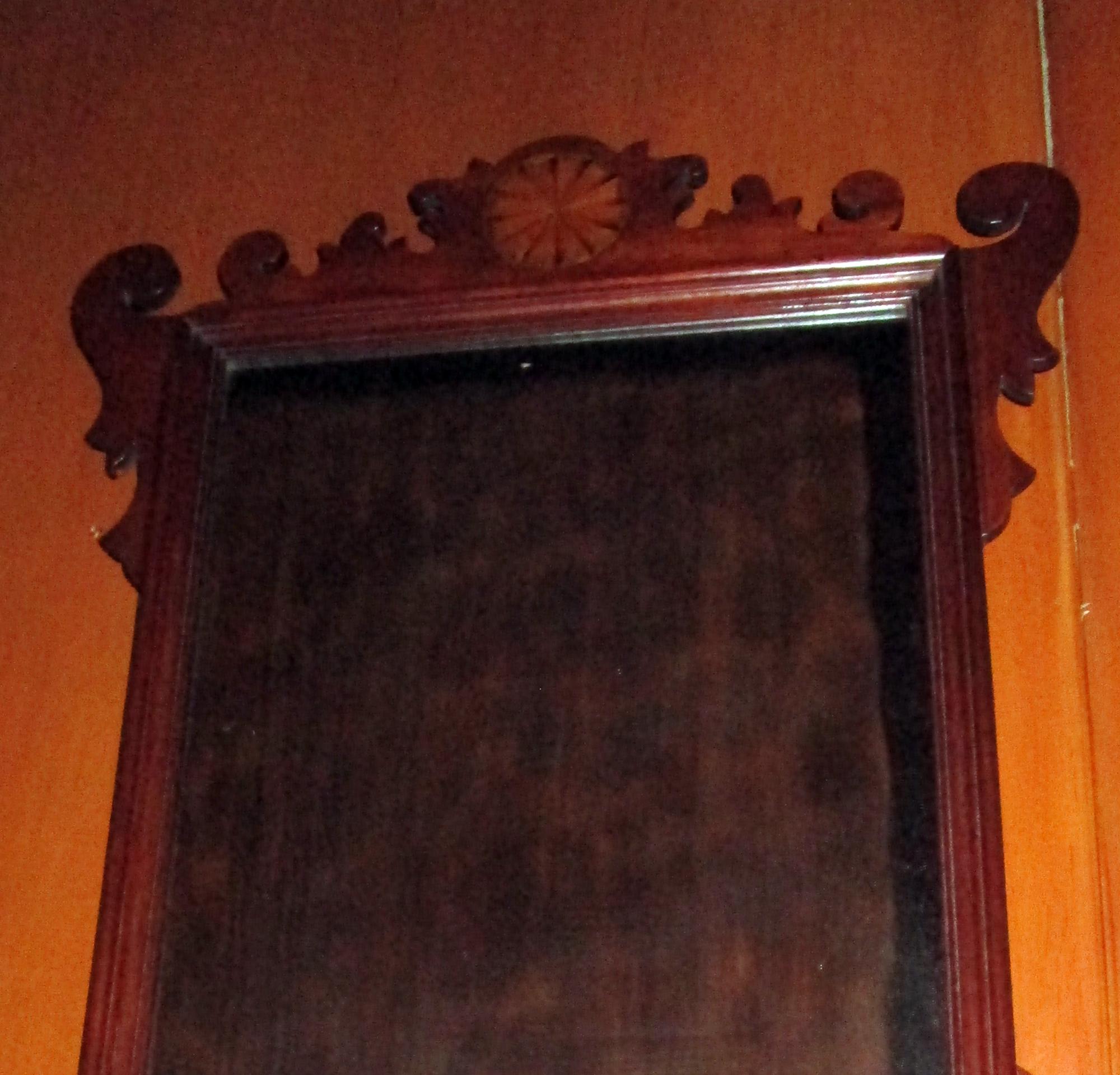 18th century English fancifully carved Chippendale mahogany mirror featuring fruitwood inlay medallions. Original finish, lovely contrasting wood tones on carved medallions.
See measurements below.