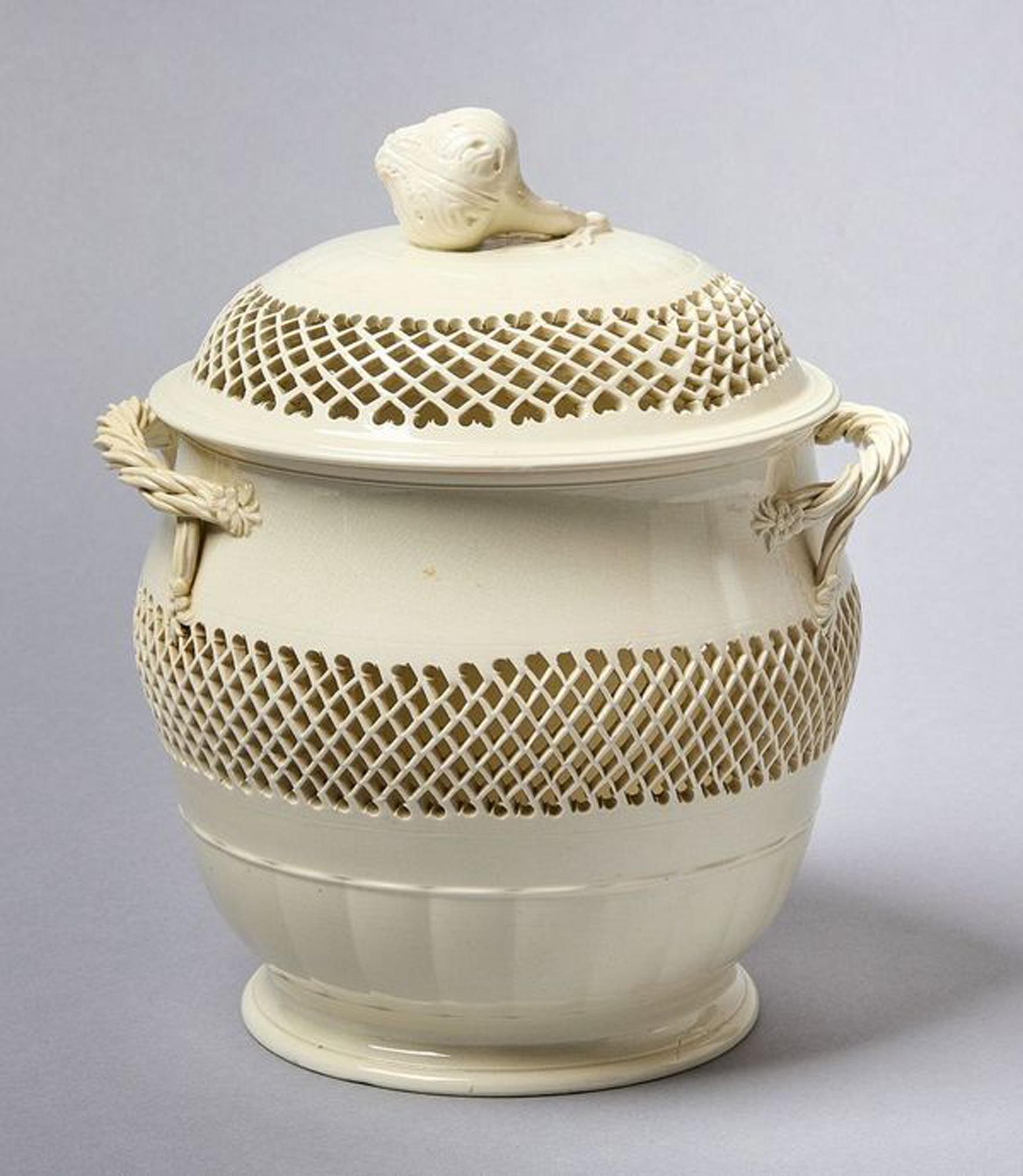 Grande vaso traforato inglese Creamware,
Probabilmente Leeds Pottery,
Circa 1780

Il grande e raro  vaso reticolato coperto in creamware con manici intrecciati a nastro e pomello a carciofo  Ha una forma circolare.  Il coperchio e il corpo