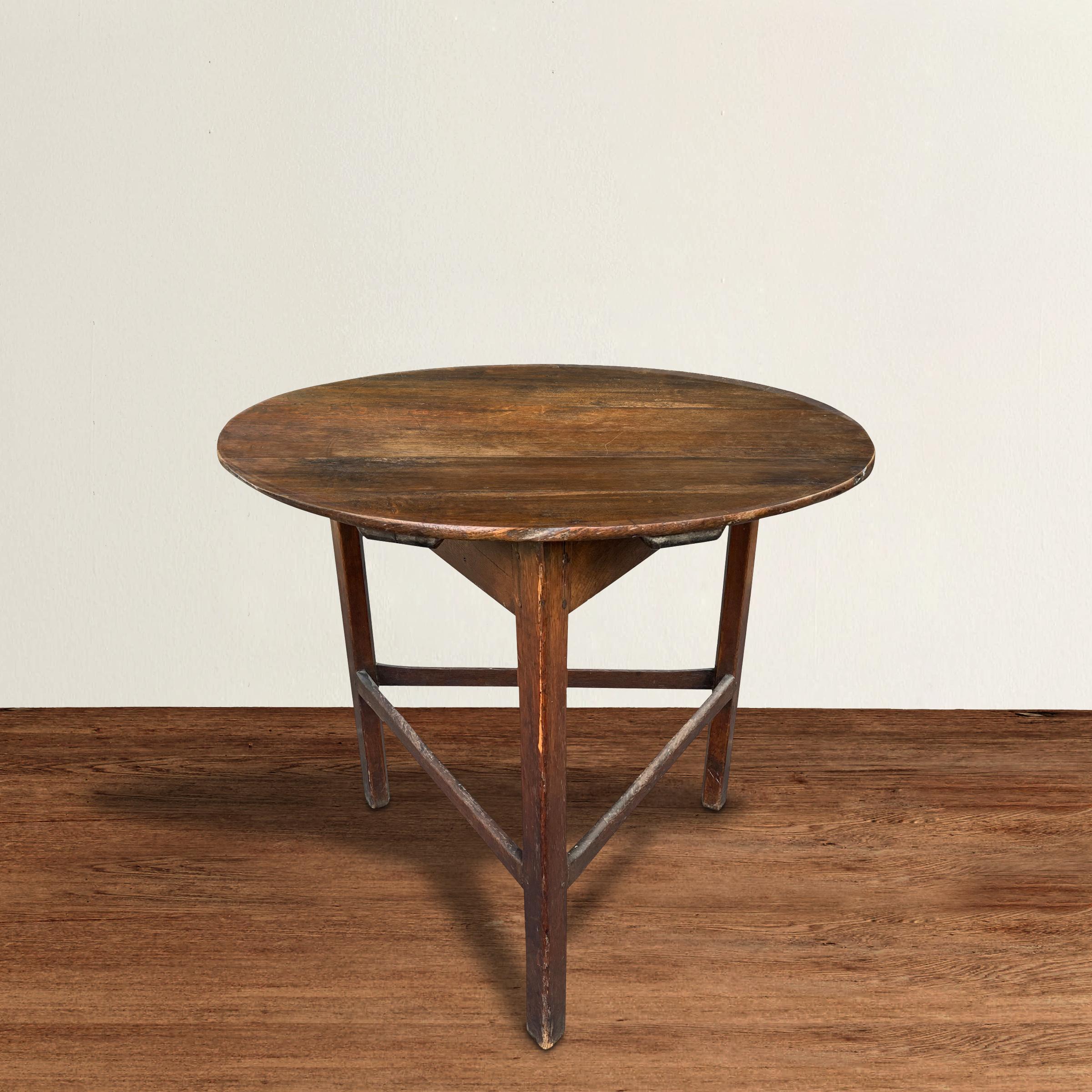 A simple but chic 18th century English cricket table with clean lines designed with three legs with simple stretchers worn from two hundred years of use, and a round top with a beautiful well-worn finish. The perfect side table, end table, or