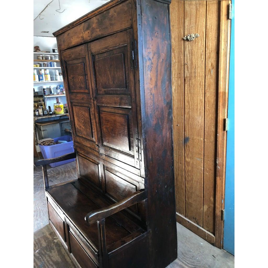 This bacon settle with attached bench perfect for a mud room or converted barn. These large settles were traditionally situated close to the fireplace. To benefit from the warmth of the fire, the back is made as a cupboard space where such