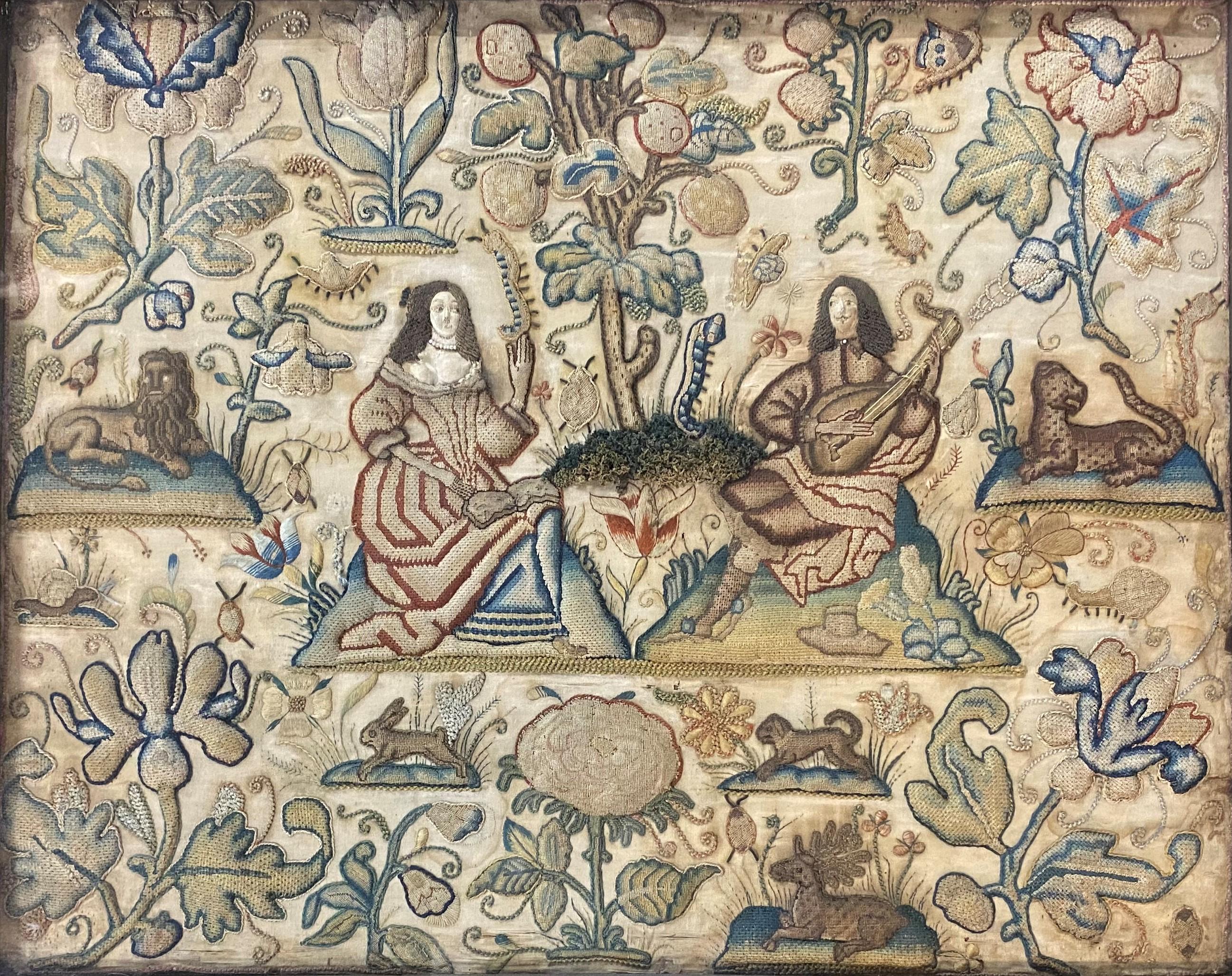 A beautifully detailed framed stumpwork textile featuring central courting figures, surrounded by lions, rabbits, and other animals, as well as plants, flowers, and other foliage. Dates to the 18 century, probably English in origin, in very good