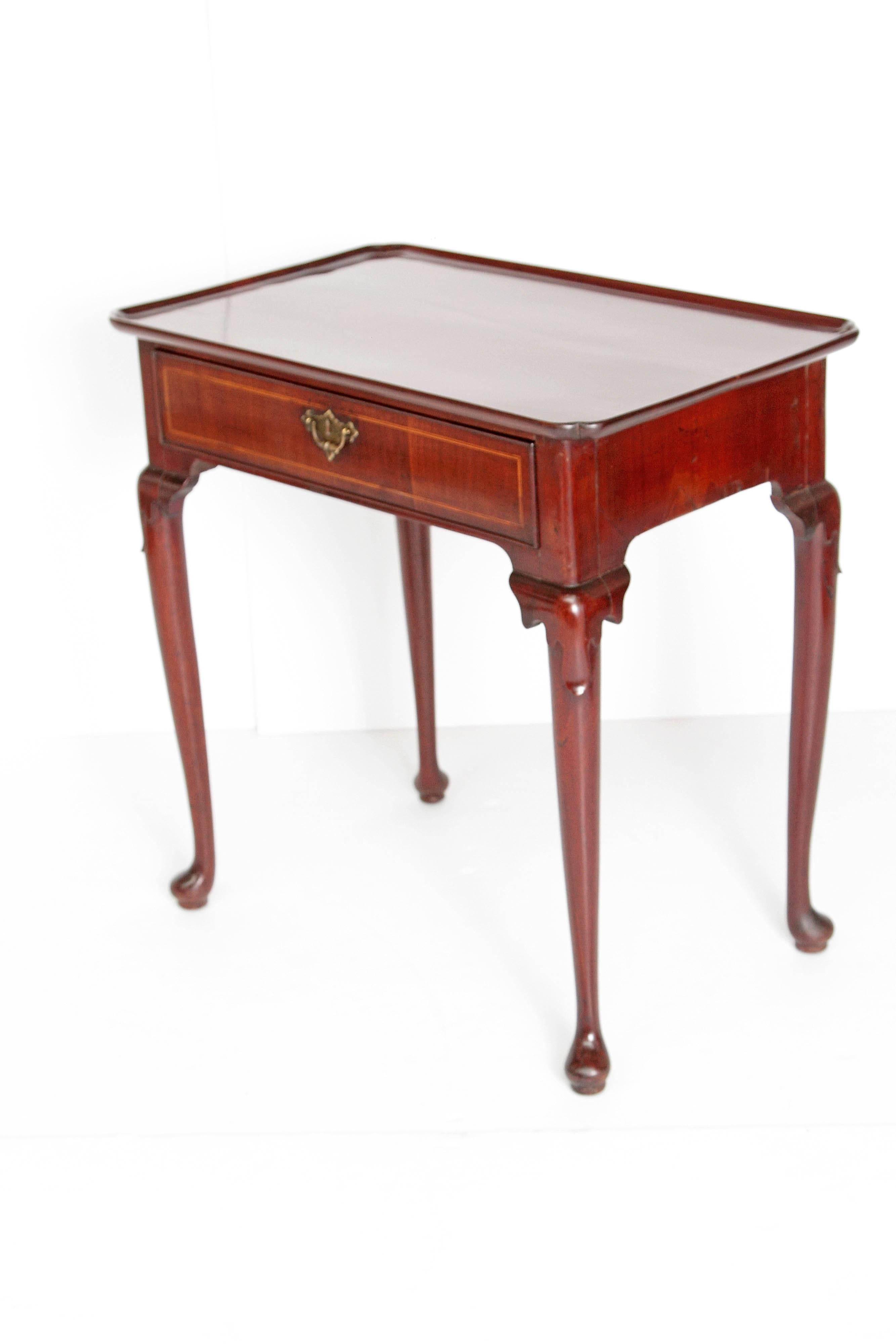 A George II English dressing table in walnut with inlaid border on drawer front. Single drawer with decorative pull on escutcheon. Cabriole legs with carving at knee and pad foot, circa 1740, England.