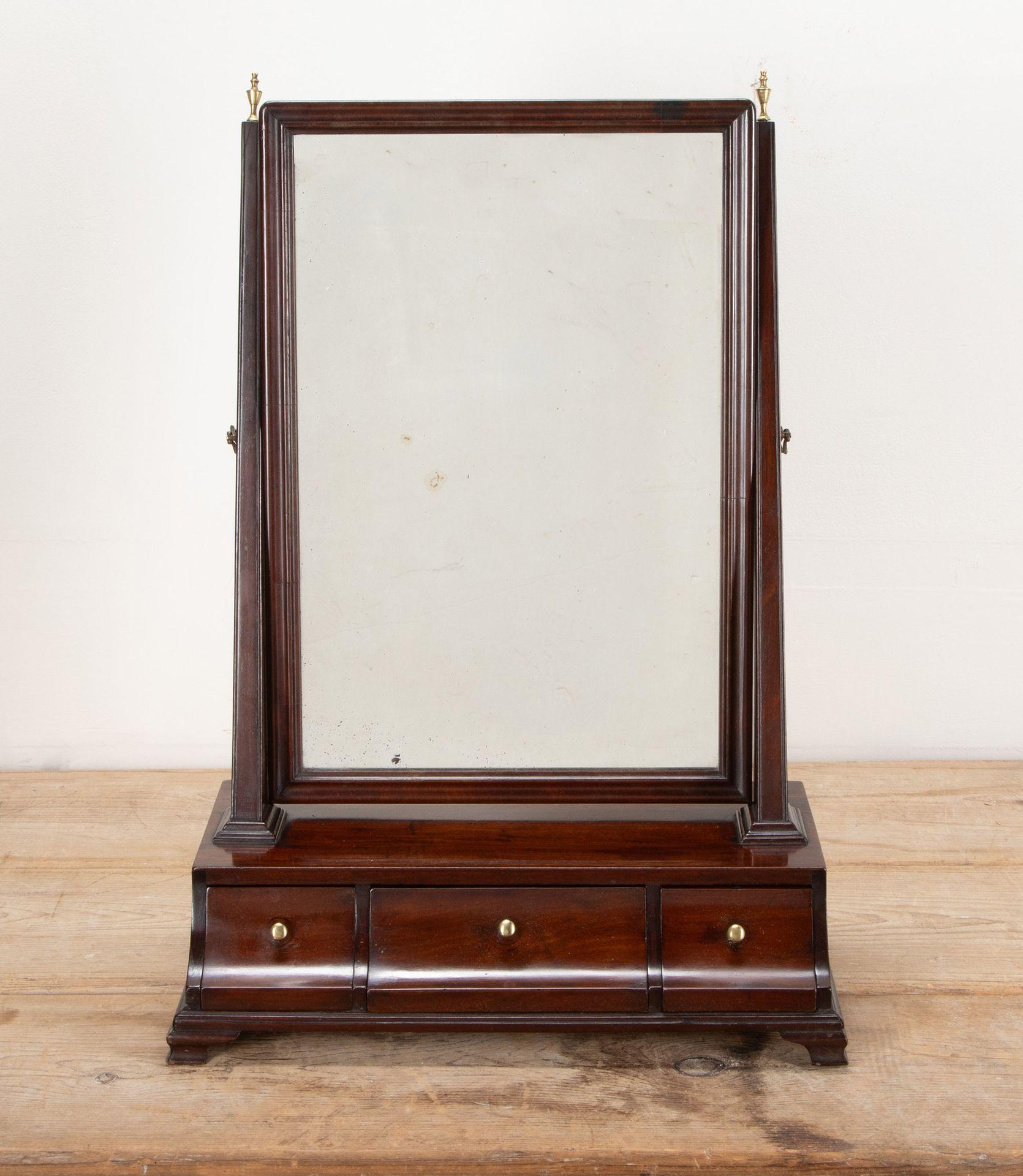 Mid-18th Century English George II mahogany dressing table mirror.  With shaped and framed glas,  supported between two uprights, on a box base fitted with two concave fronted drawers and raised on small bracket feet. 
A classical early mirror from
