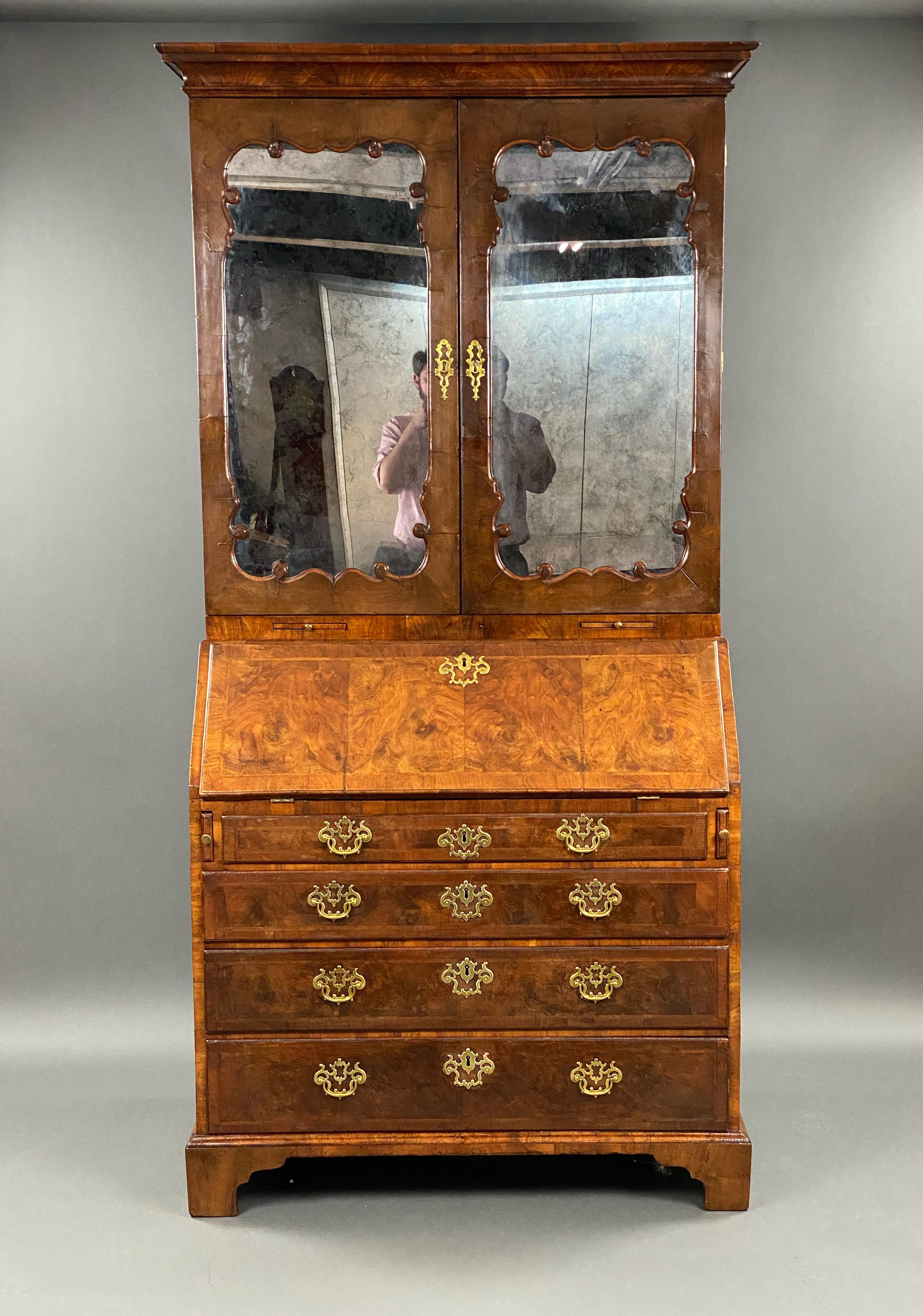 For sale is a fine quality 18th century English George II walnut secretary bookcase in the manner of Giles Grendey. The shaped mirrored panel doors opening to reveal a fully fitted interior comprising of pigeon holes, small drawers and a cupboard to