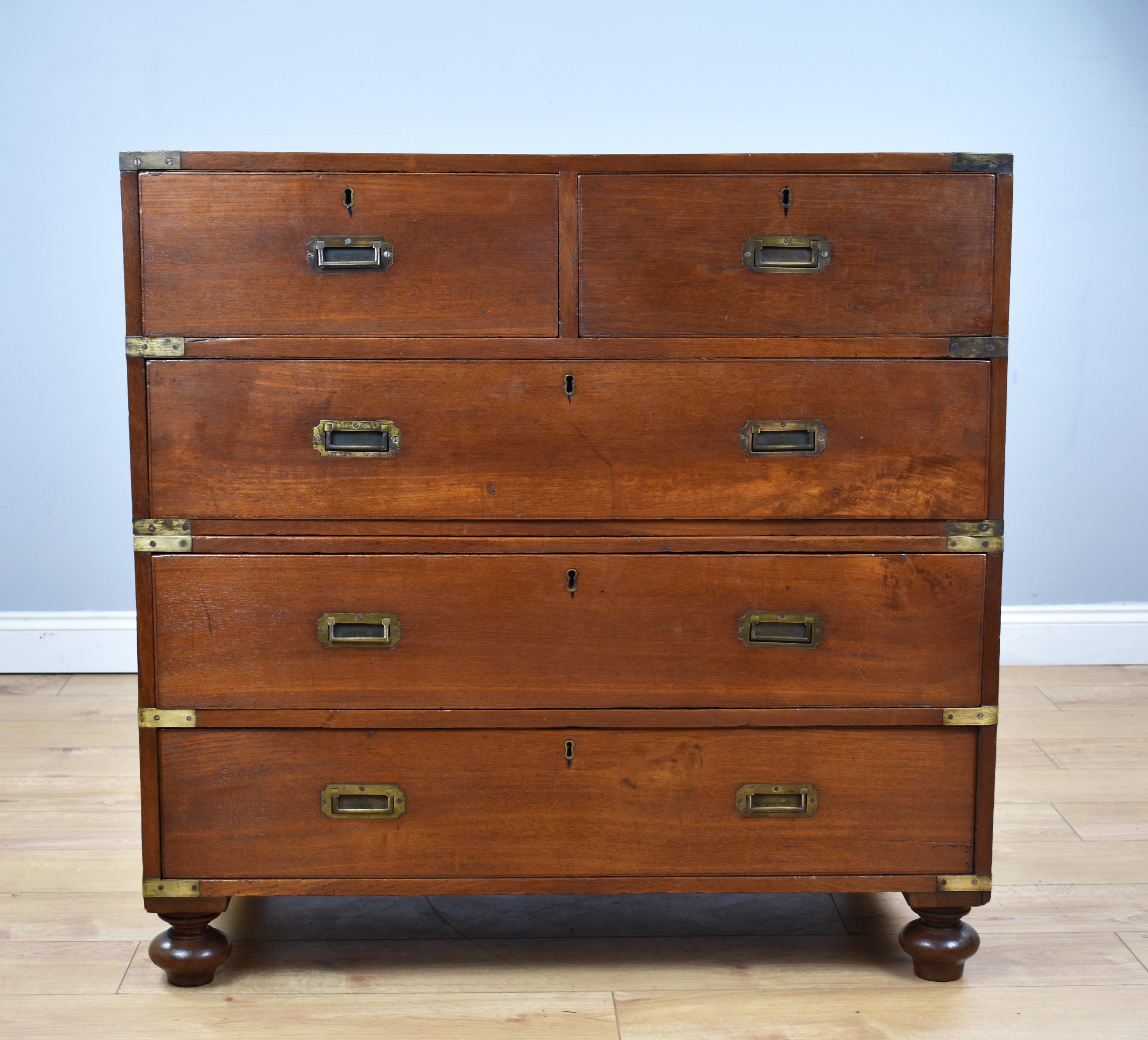 For sale is a good quality George III Campaign chest, having brass corners and original iron handles to each end of each section, with an arrangement of five drawers, each with original handles, standing on original removable turned feet. The chest