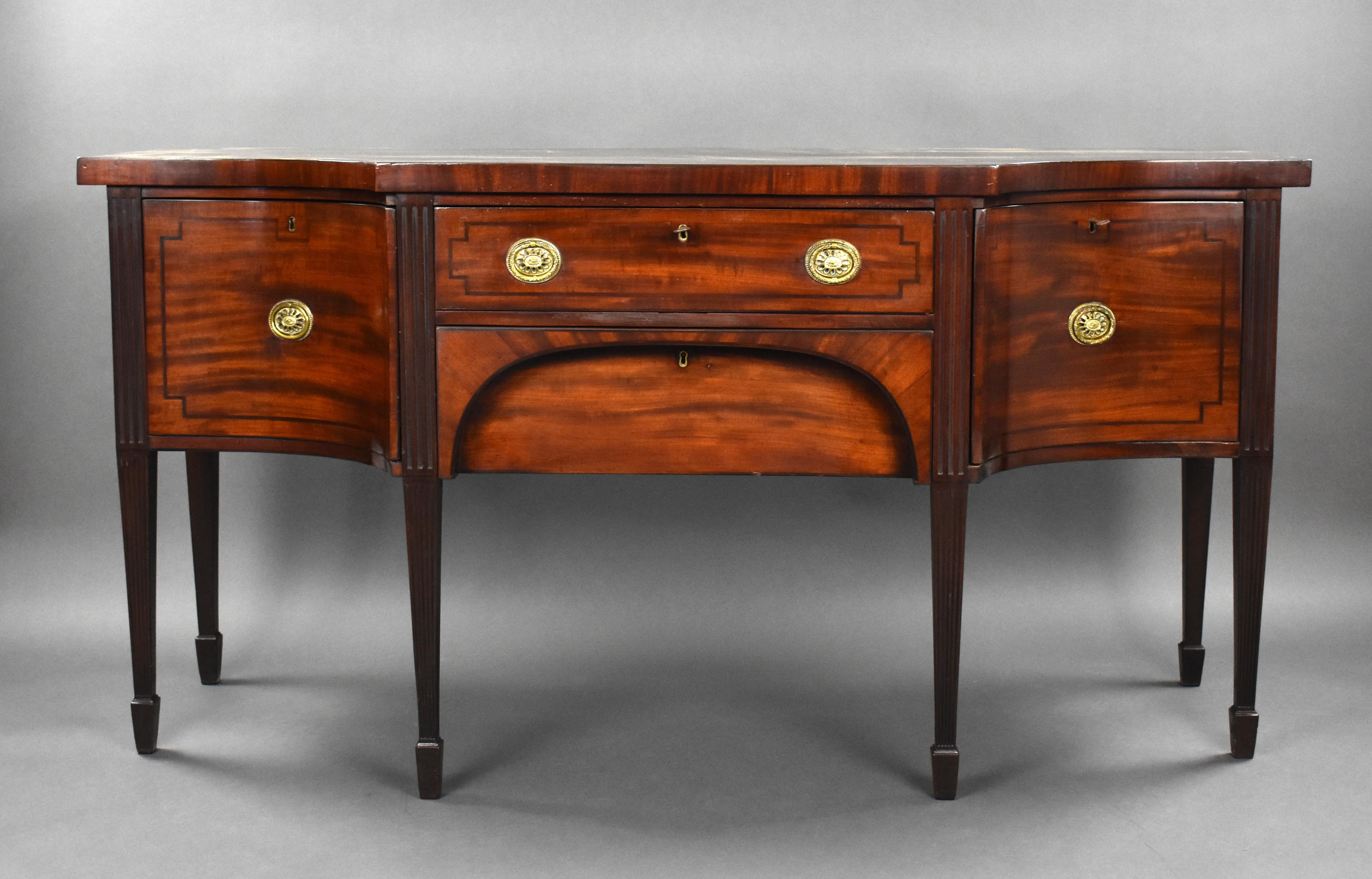 For sale is a good quality George III mahogany sideboard, having a central long drawer and frieze drawer below flanked by concave deep drawers, each inlaid with black line having brass ring handles standing on tapered legs terminating on spade feet.