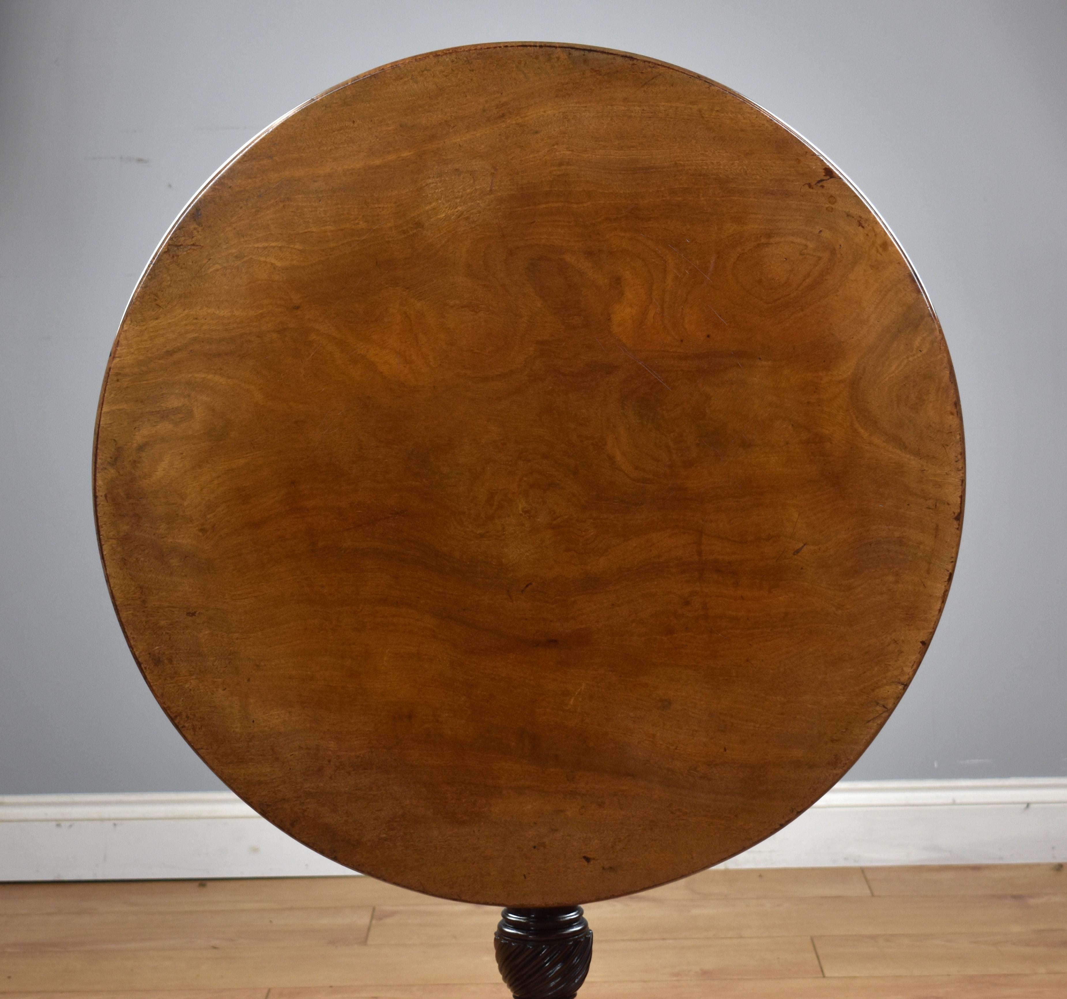 A very good quality George III mahogany tripod table, having a single piece solid mahogany top, above a bird cage mechanism above a turned stem with a writhed carving to the base, above three elegant legs. The table remains in good untouched
