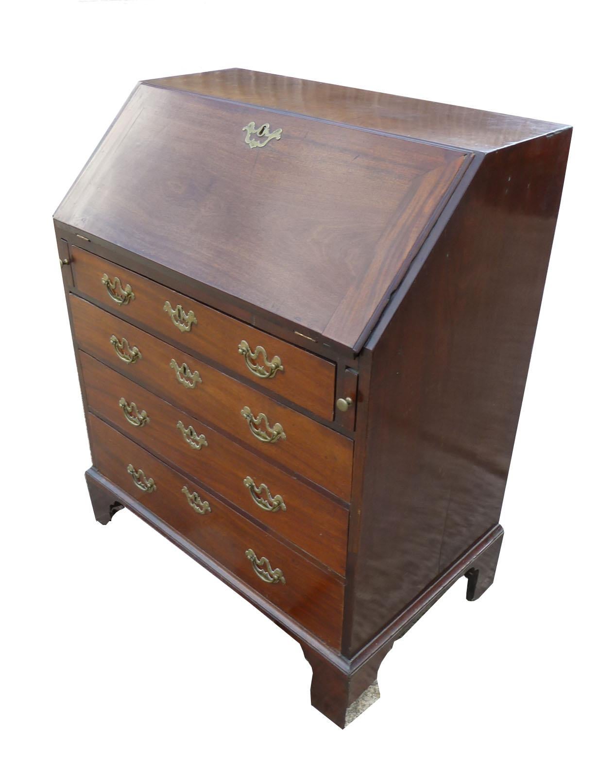 For sale is a good quality, unusual, small George III red walnut bureau. The bureau has a fall front opening to reveal a fitted interior including several drawers as well as pigeon holes. Below this the bureau has four drawers, each with original